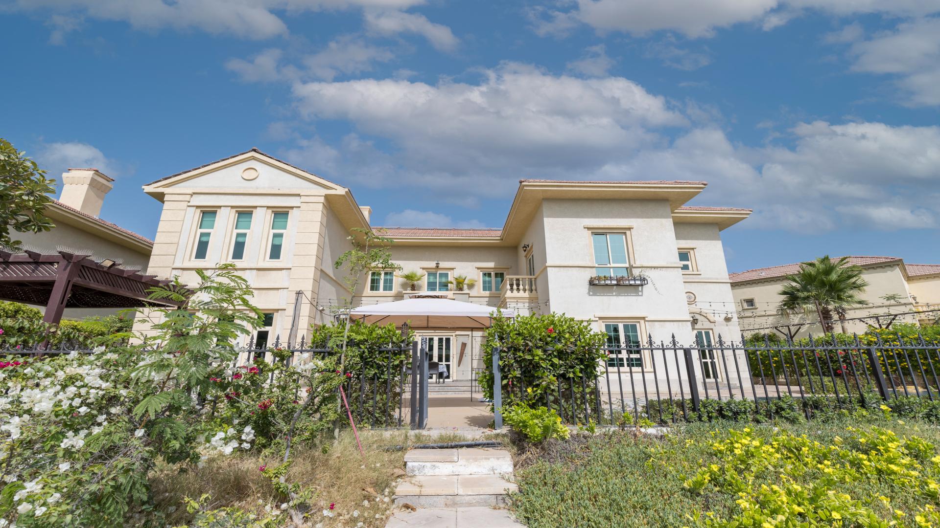 Spacious living room in Jumeirah Islands villa with TV, sofa, and natural light