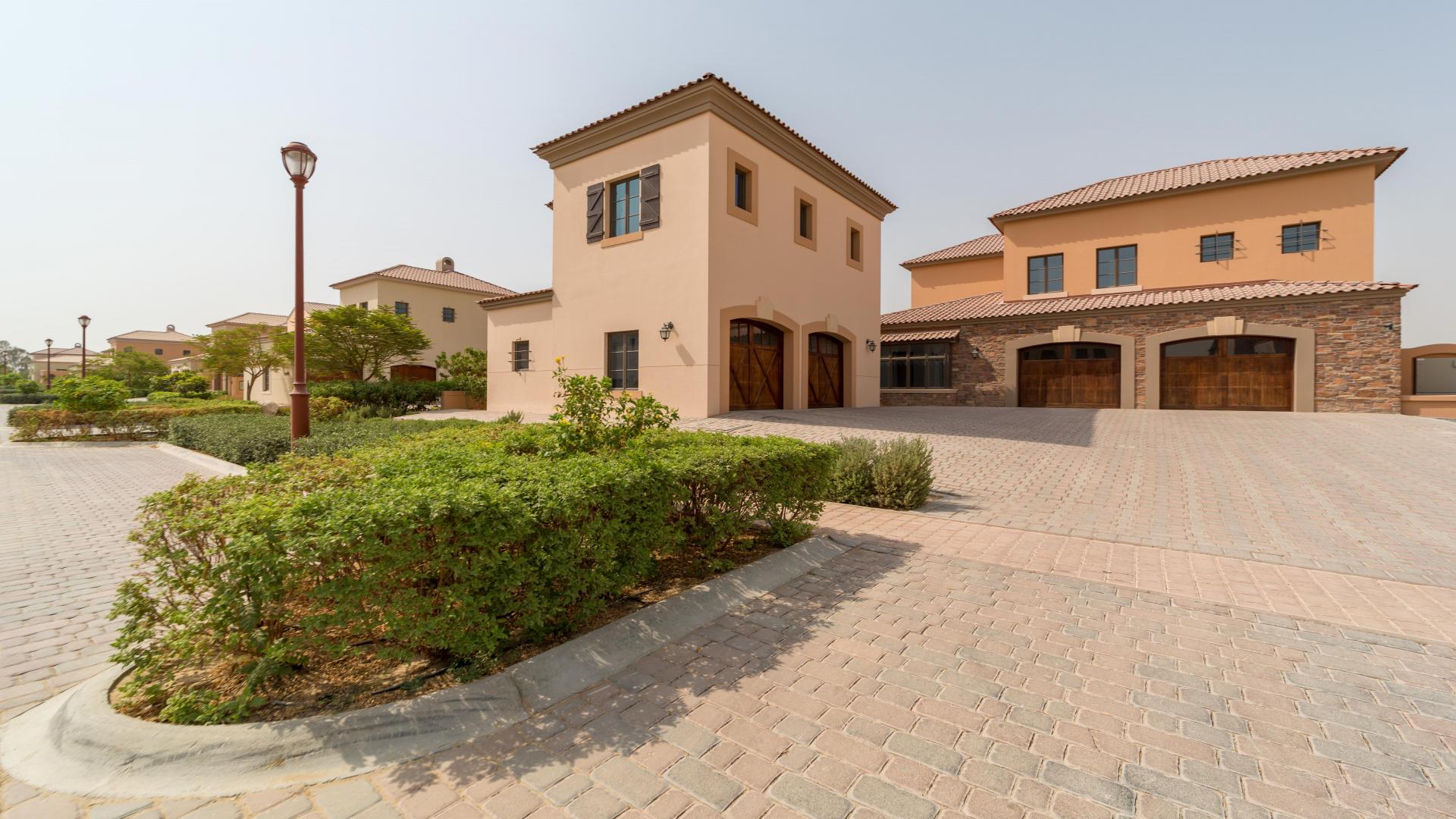 Villa exterior at Jumeirah Golf Estates, Fire community, with stone facade and landscaped path