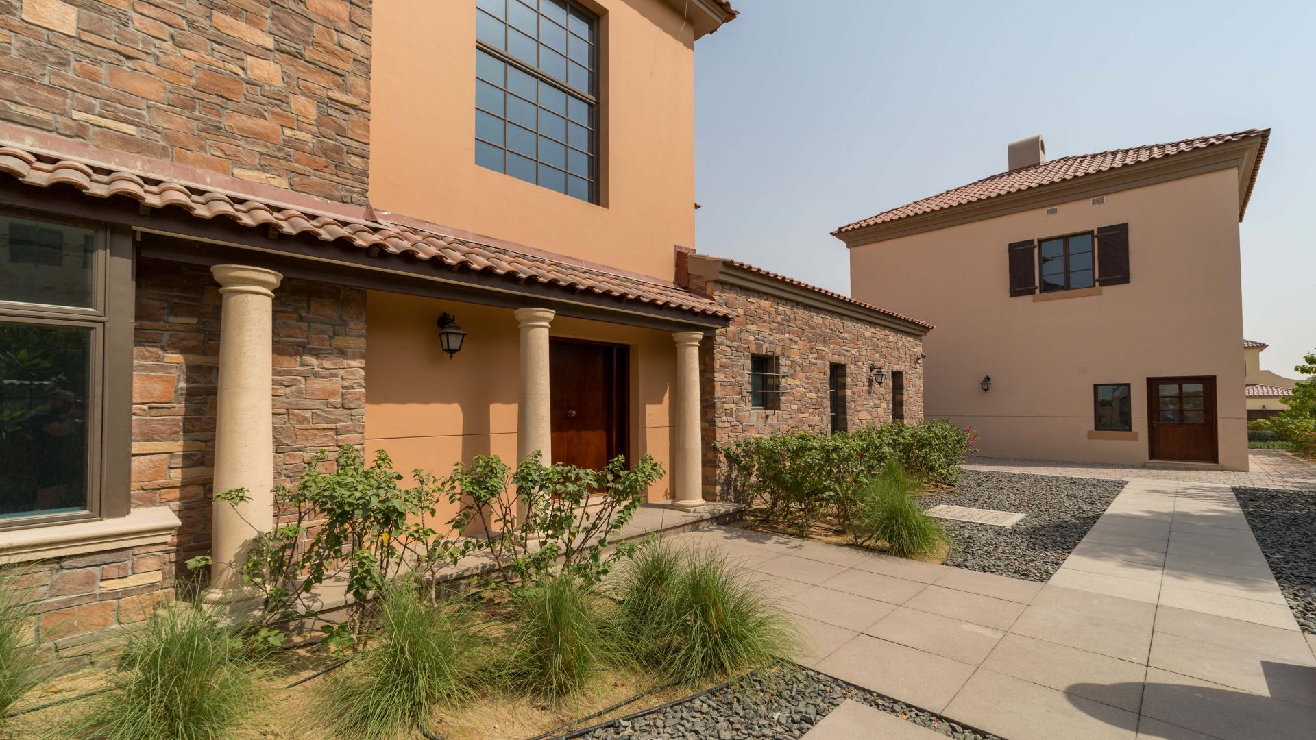 Villa exterior in Jumeirah Golf Estates Fire community, featuring spacious driveway and landscaping