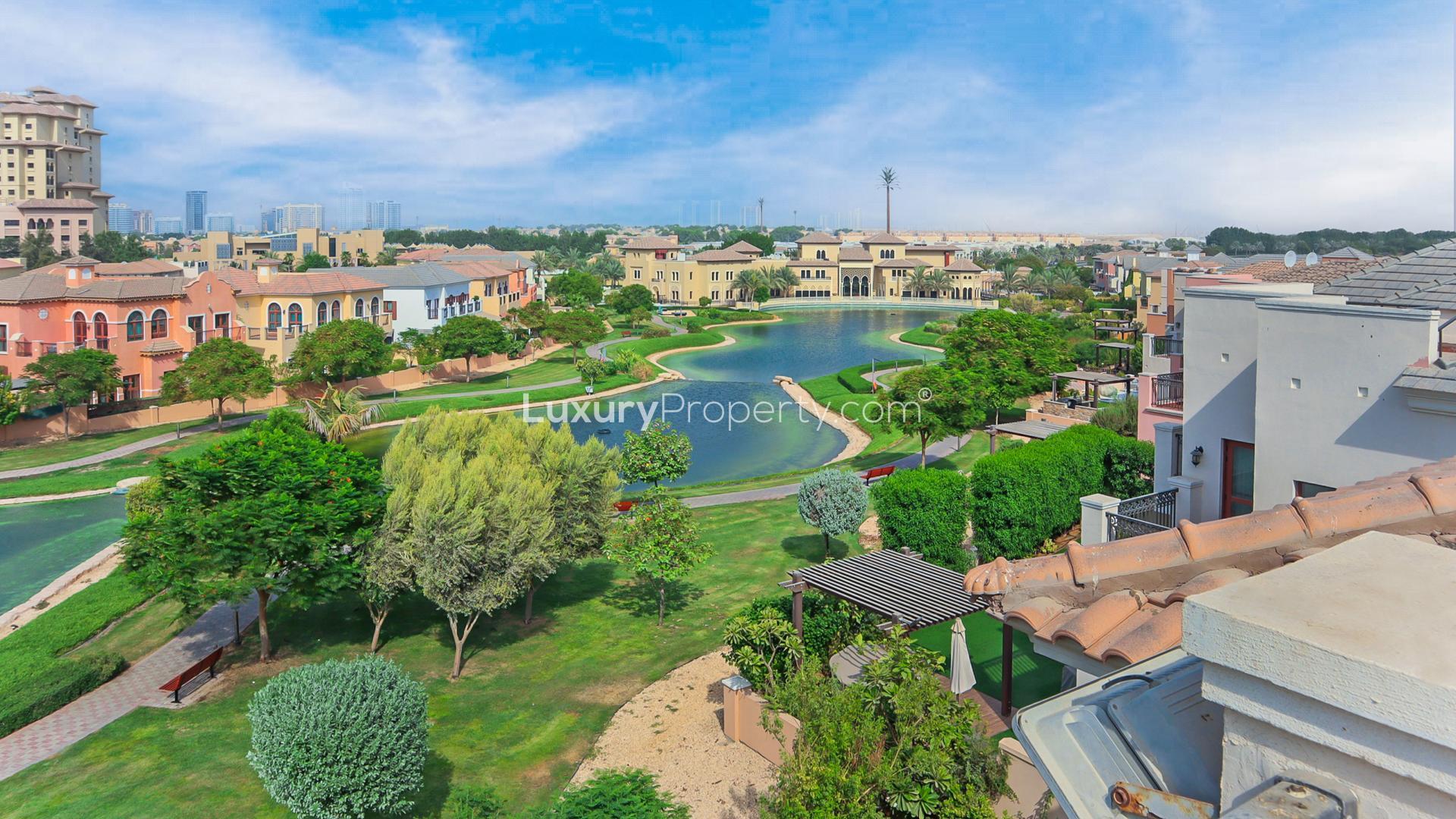 Outdoor pool at Jumeirah Golf Estates villa for rent, surrounded by lush greenery