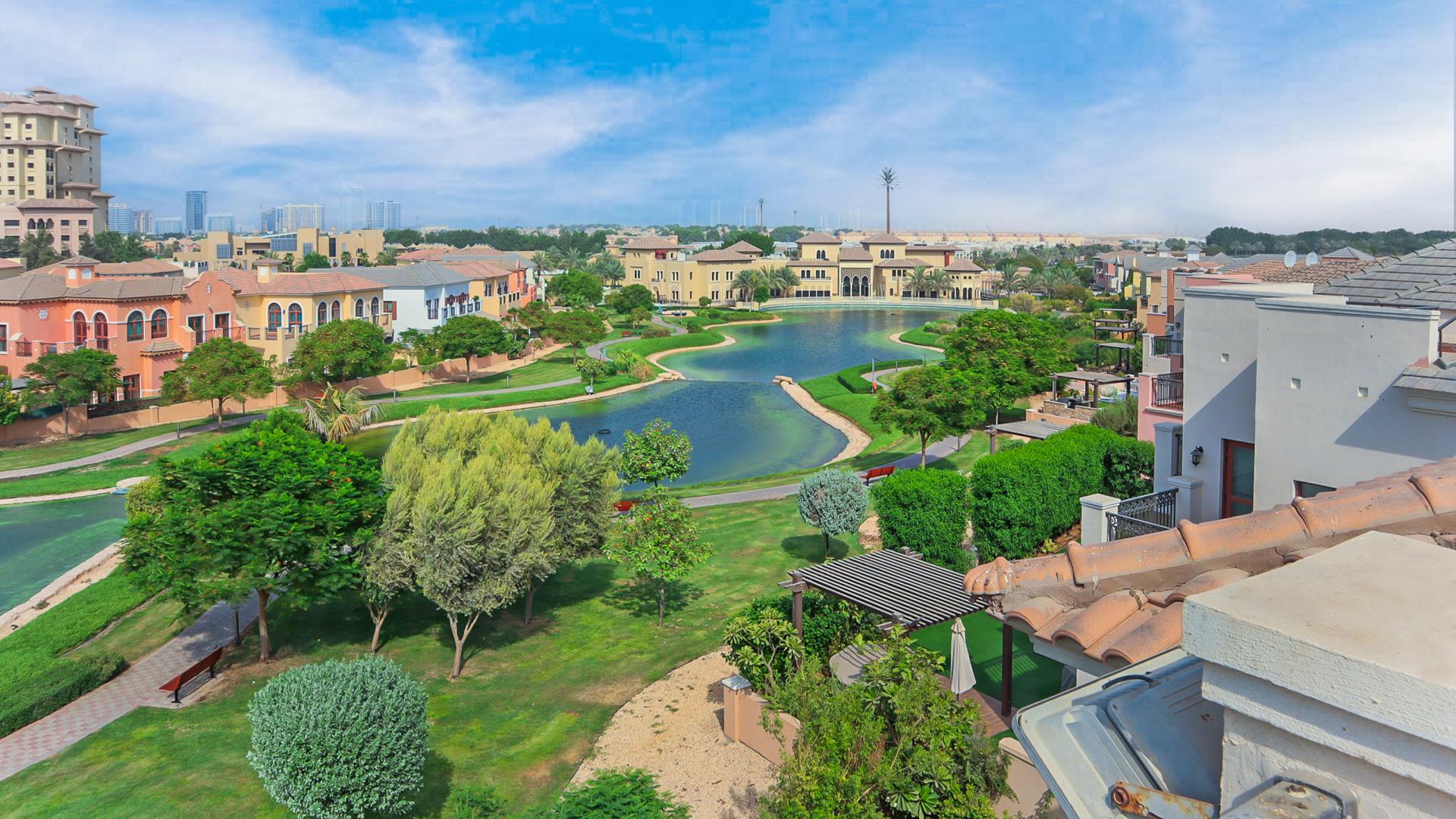 Outdoor pool at Jumeirah Golf Estates villa for rent, surrounded by lush greenery