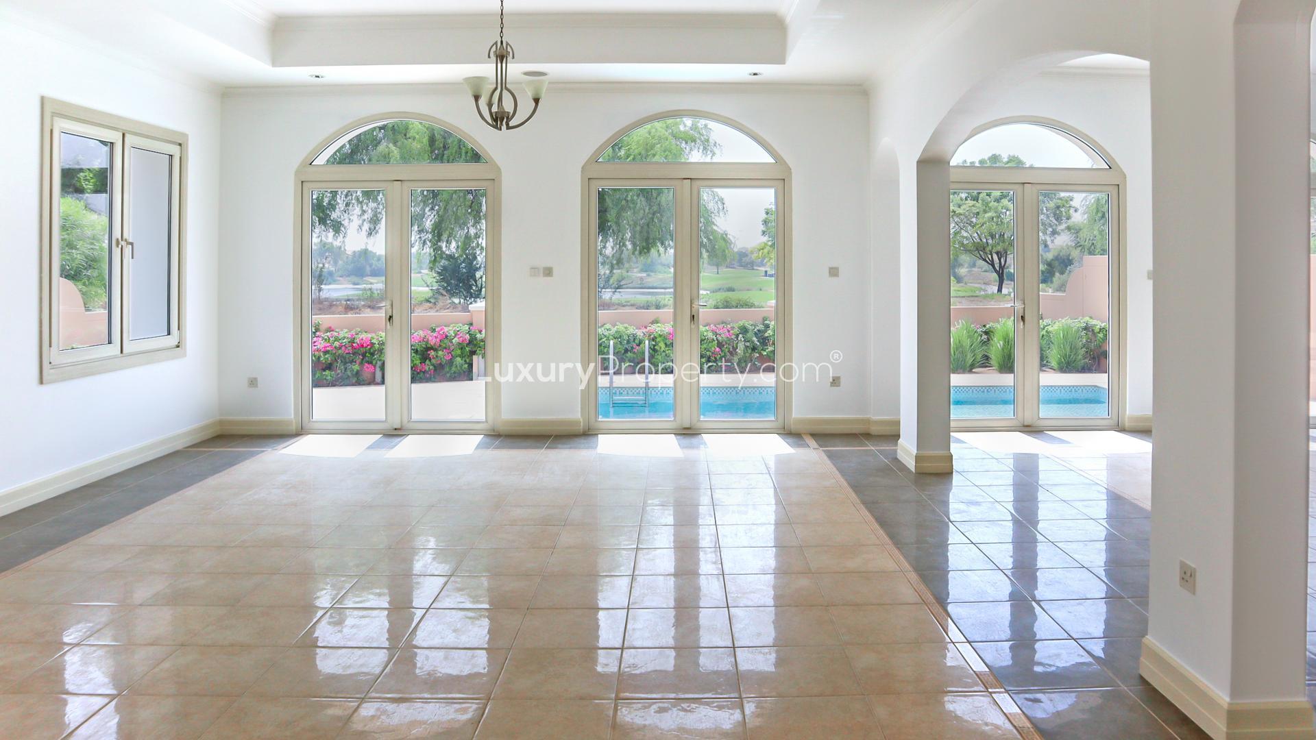 Spacious villa interior with large windows overlooking Jumeirah Golf Estates, Fire community