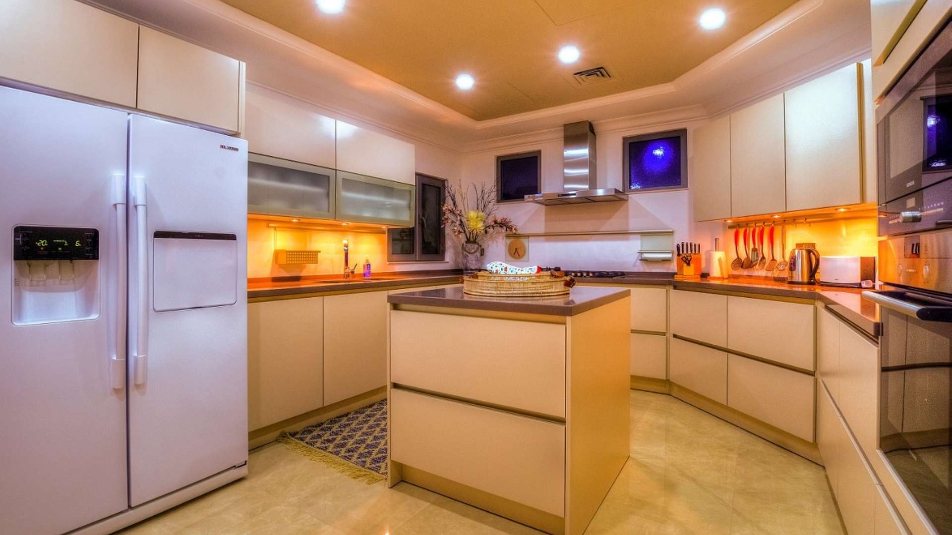 "Spacious bedroom in fully furnished 5-bed villa, Palm Jumeirah, with elegant decor.",Luxurious modern kitchen in fully furnished 5-bed villa, Palm Jumeirah Garden Homes