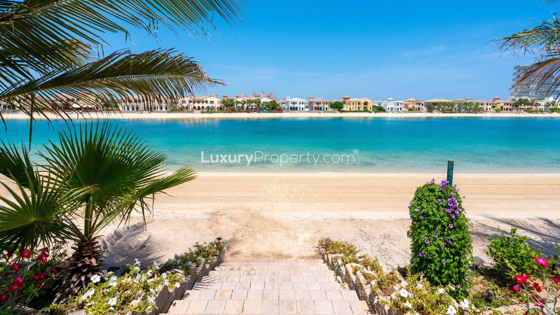 Beachfront view of luxury villas on Palm Jumeirah, Dubai, with clear blue waters