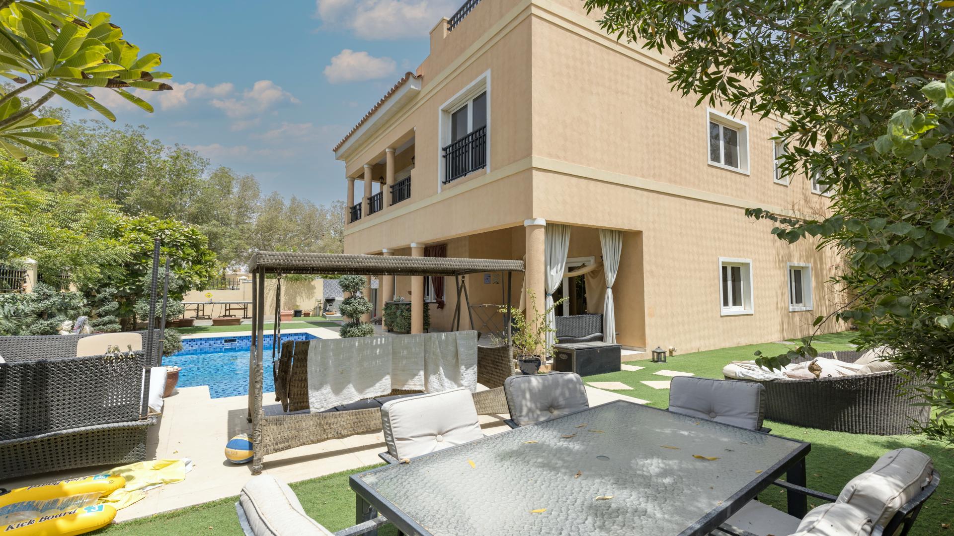 "Elegant 5-bedroom villa exterior with driveway in Hacienda, The Villa community.",Exterior view of 5-bedroom villa with pool, patio furniture, and landscaped garden in Hacienda