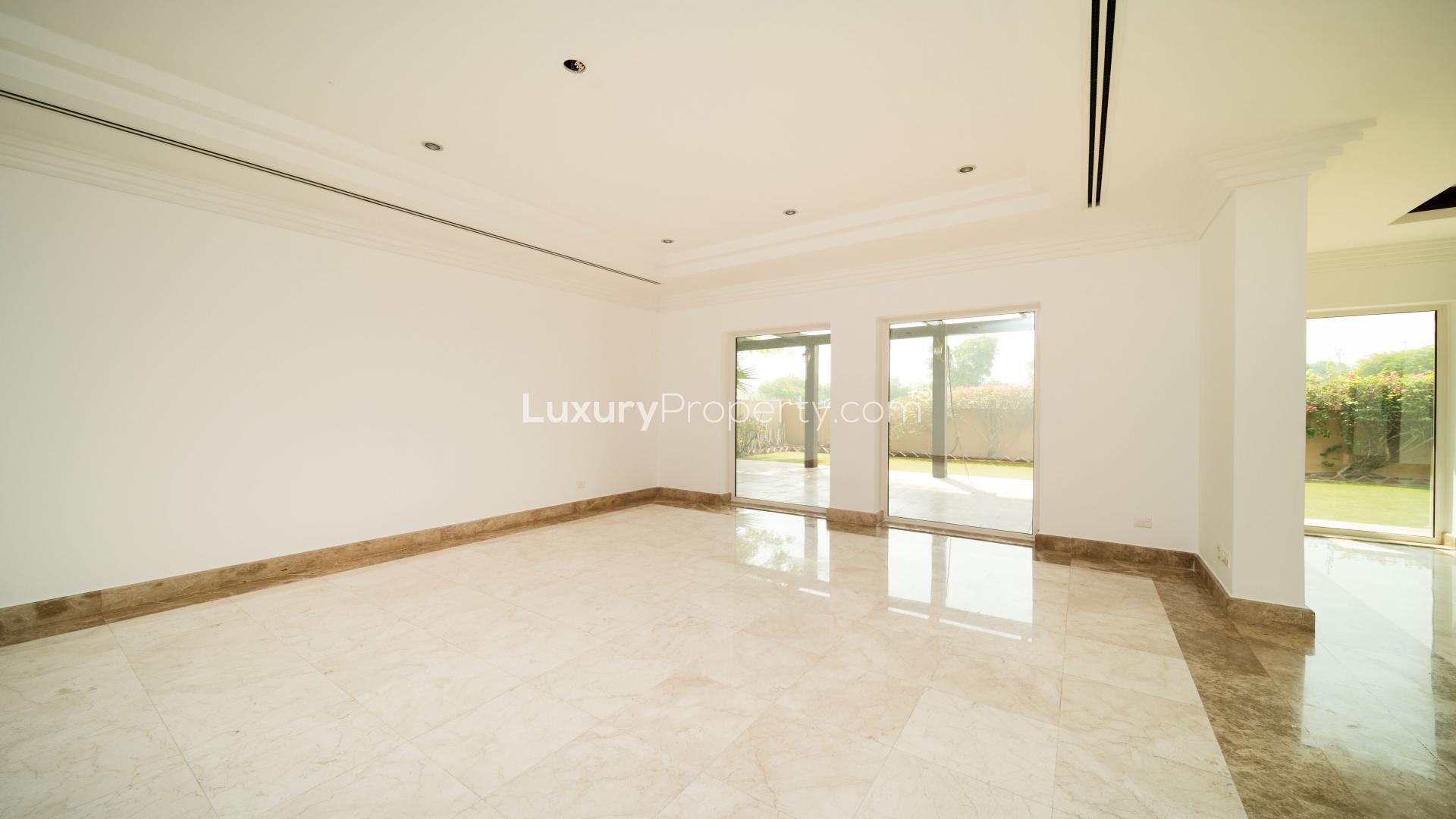 "Spacious living room with marble flooring in E1 Hattan Villa, The Lakes, Emirates Living.",Empty living room in E1 Hattan Villa, The Lakes, Emirates Living, marble floors, garden view