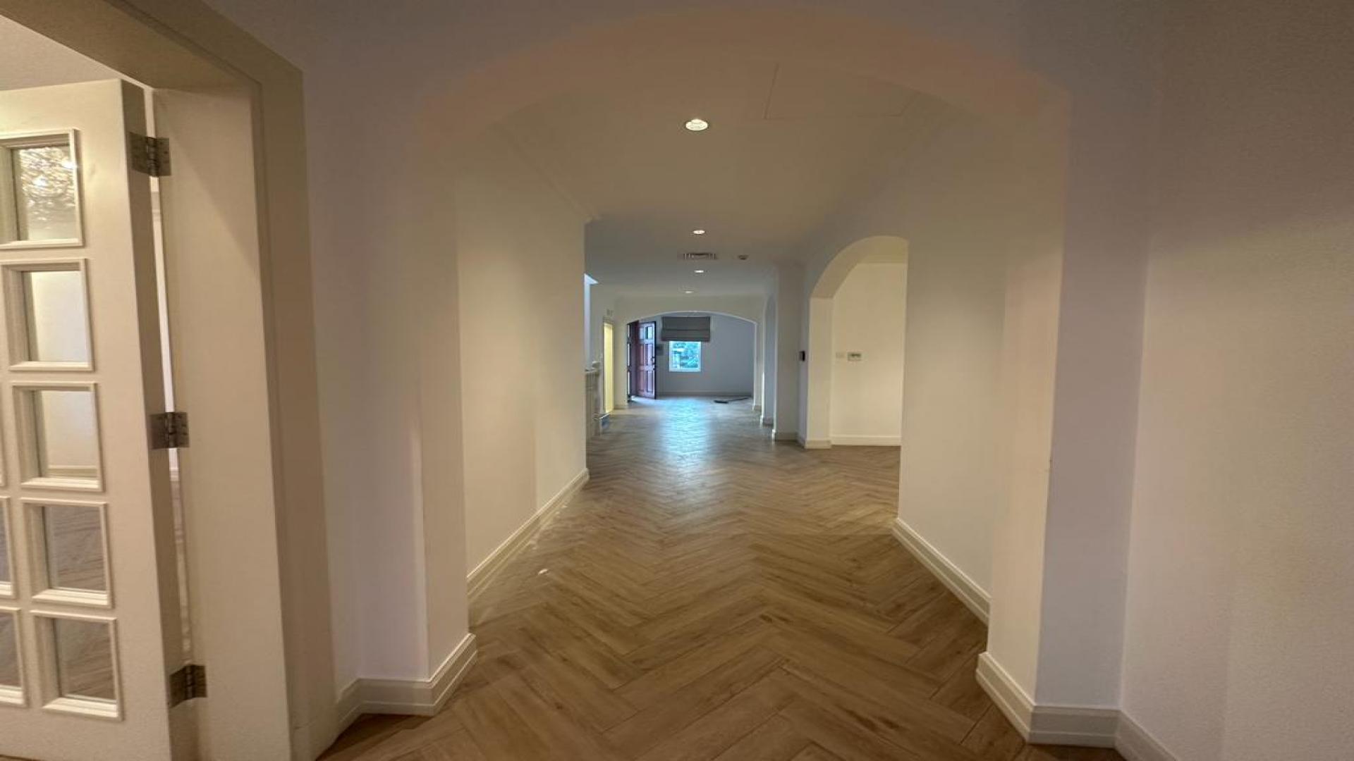 Bright living room in Jumeirah Golf Estates villa with chandelier and garden view