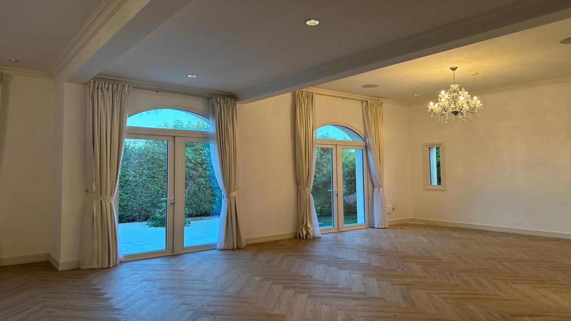 Spacious living room in Jumeirah Golf Estates villa for rent, elegant chandelier and large windows