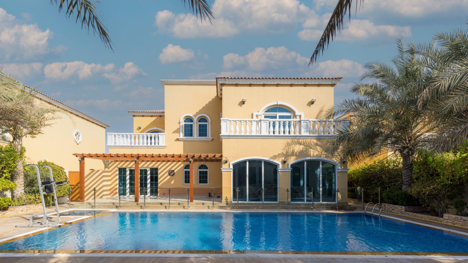 Spacious living area in 5-bedroom villa, Jumeirah Park Legacy, with chandeliers and large windows
