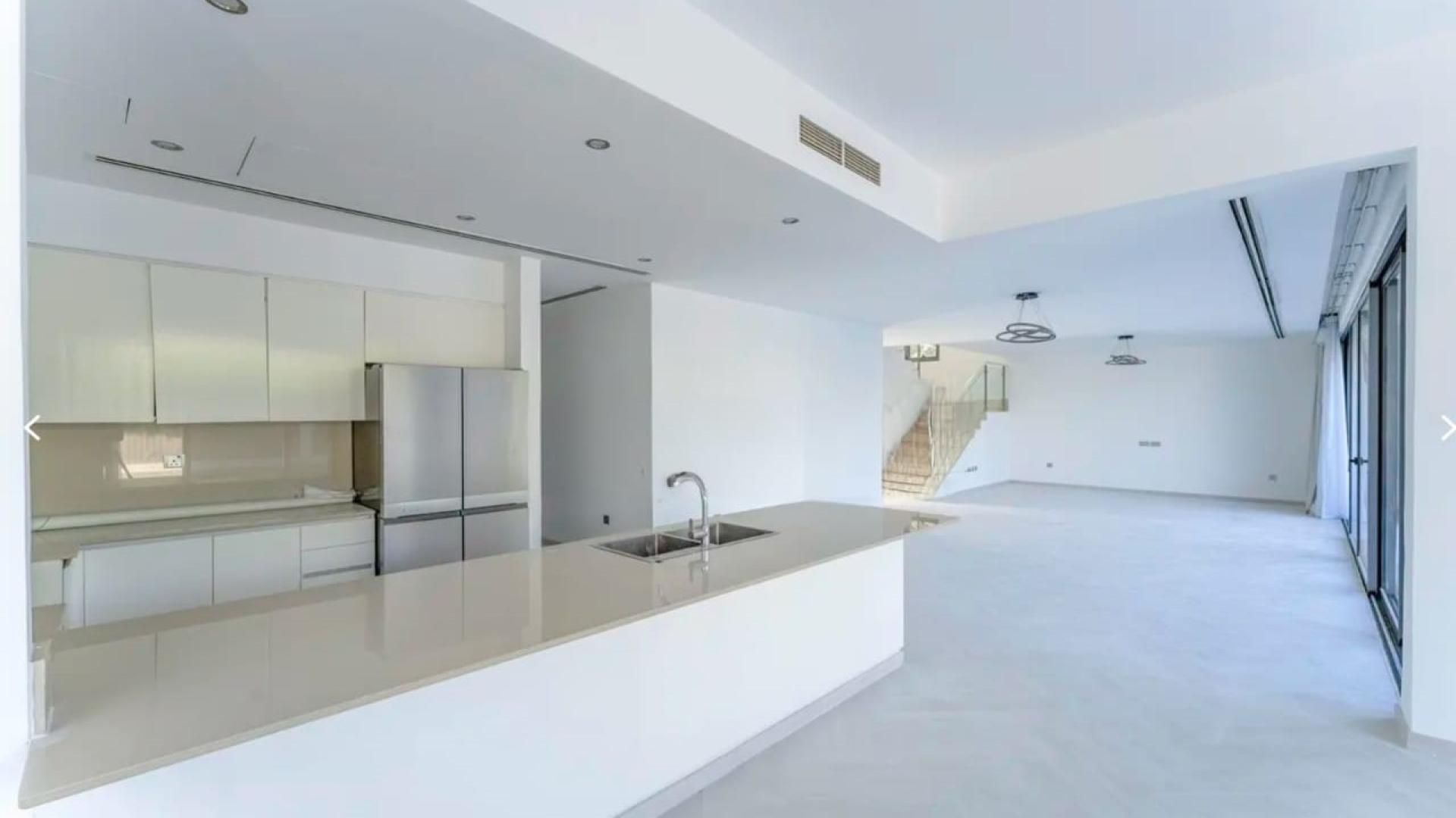 Bright open-plan living area in Sidra Villas, Dubai Hills Estate, featuring modern kitchen and staircase