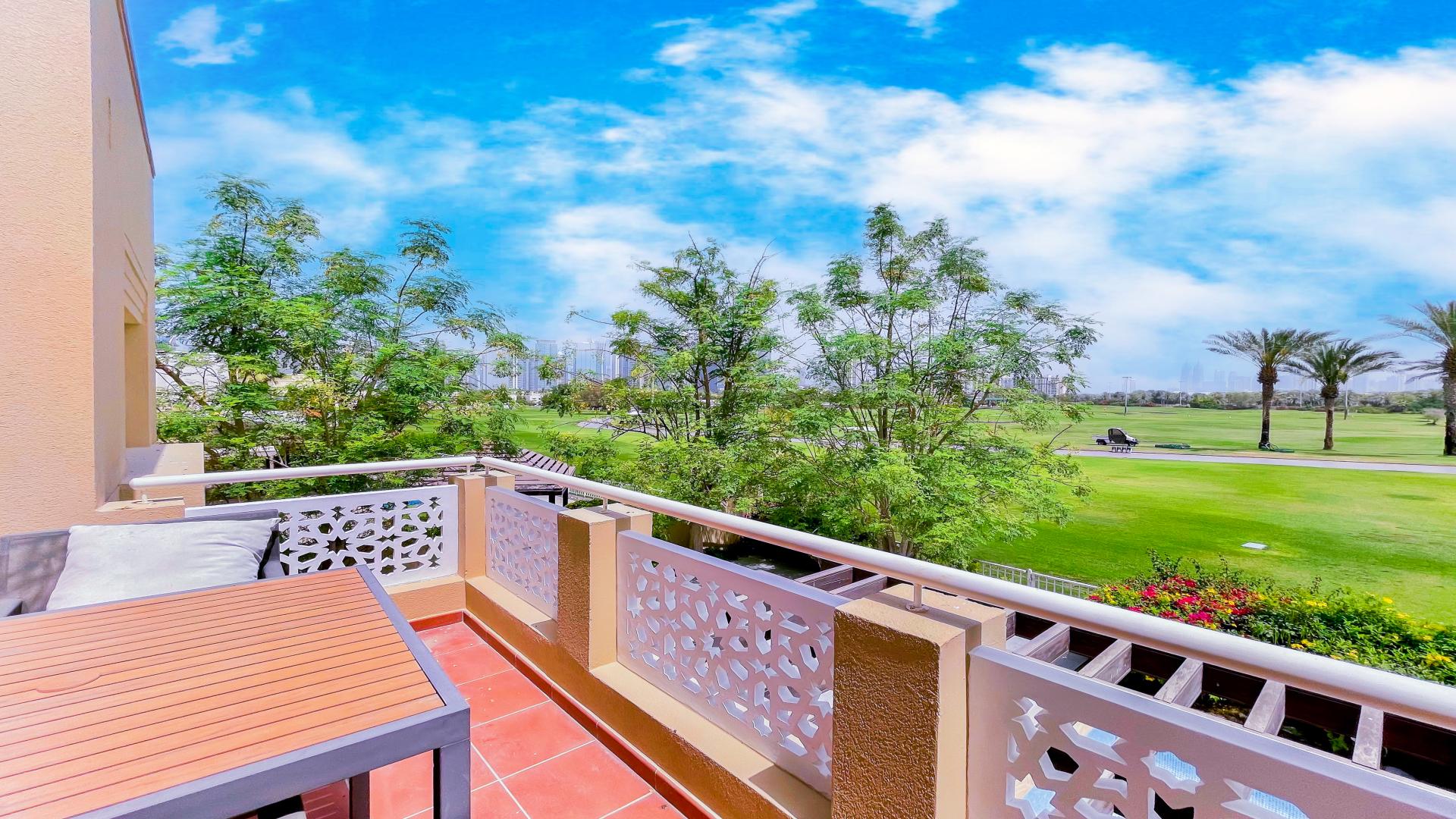 Living room with TV unit, pool view, and garden in Meadows 4 villa for rent