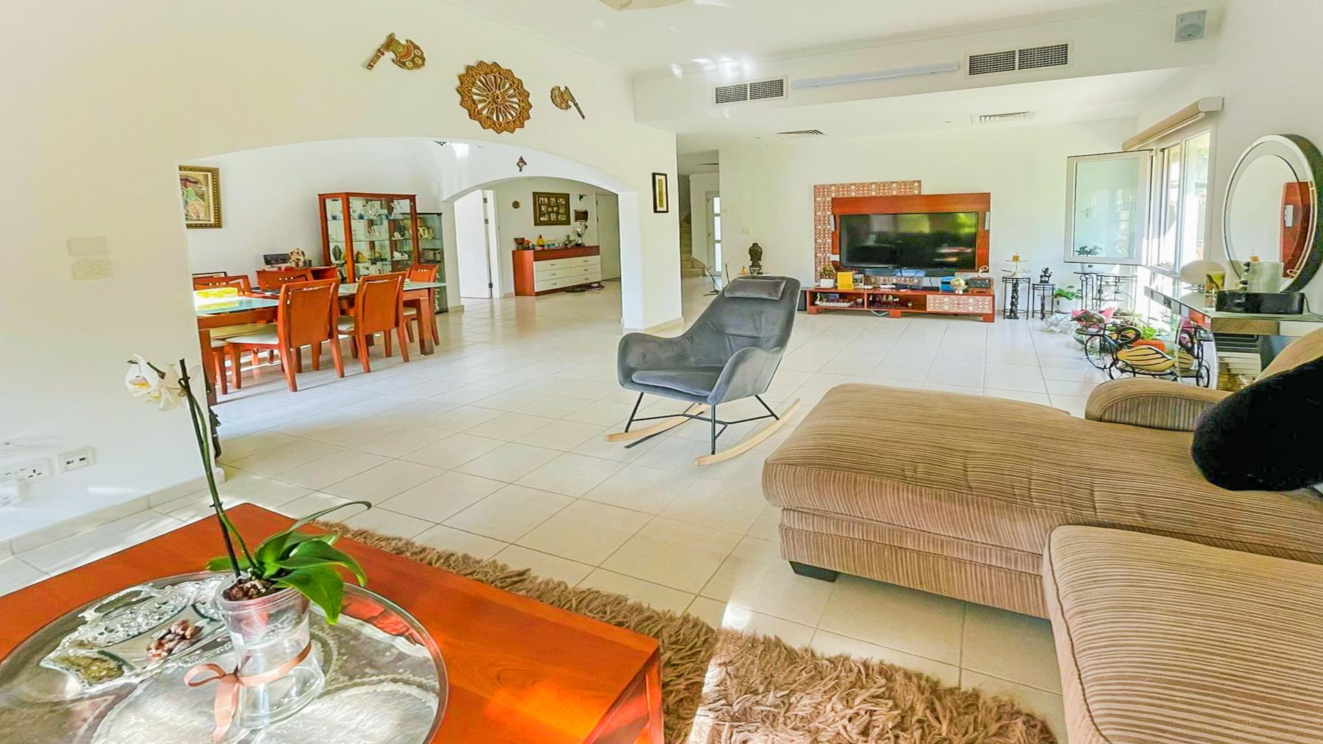 "Spacious villa with lush garden in Meadows 8, featuring extended plot and upgraded kitchen.",Spacious living room in Meadows 8 villa with elegant decor and modern furnishings