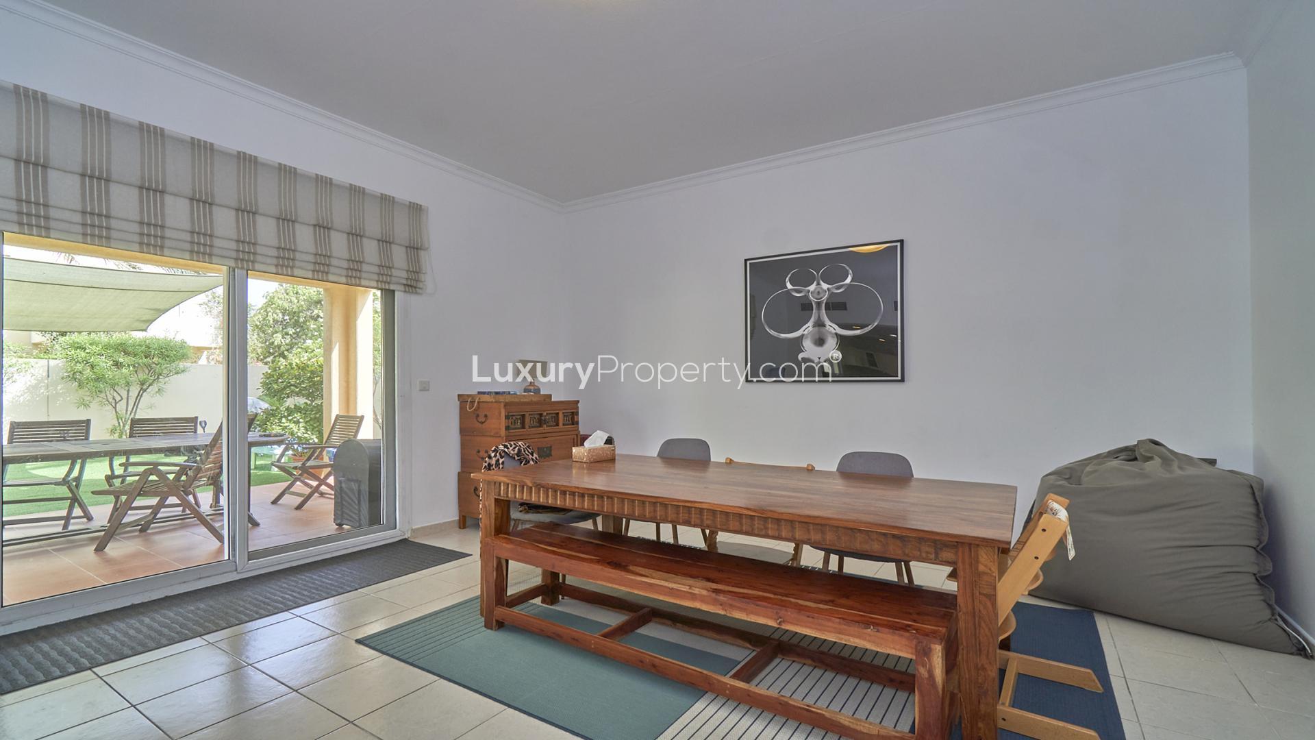 "Spacious terrace with garden view in Meadows 6 villa for rent, LP13560.",Dining area with wooden table in Meadows 6 villa, overlooking garden patio
