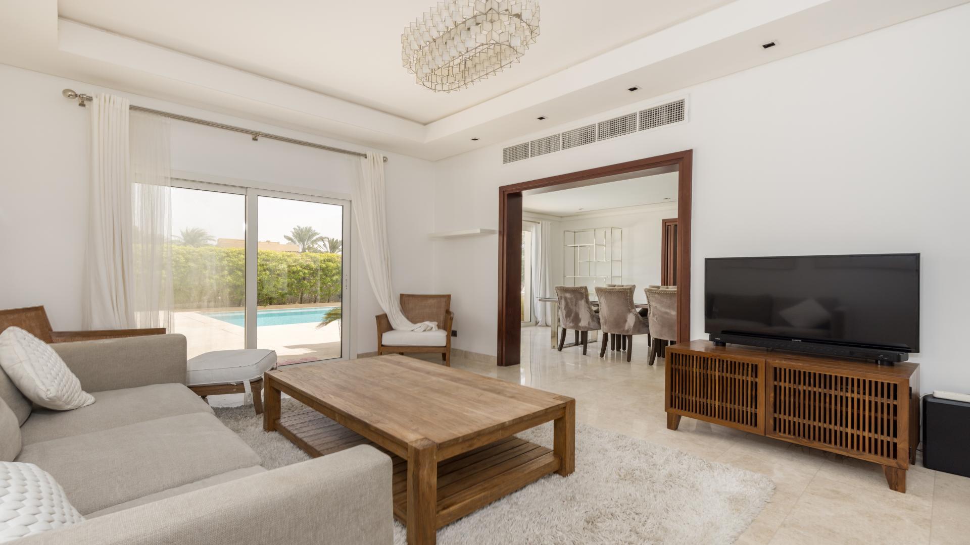 "Modern villa with private pool and garden in Meadows 7, available for rent.",Living room with pool view in upgraded Meadows 7 villa for rent