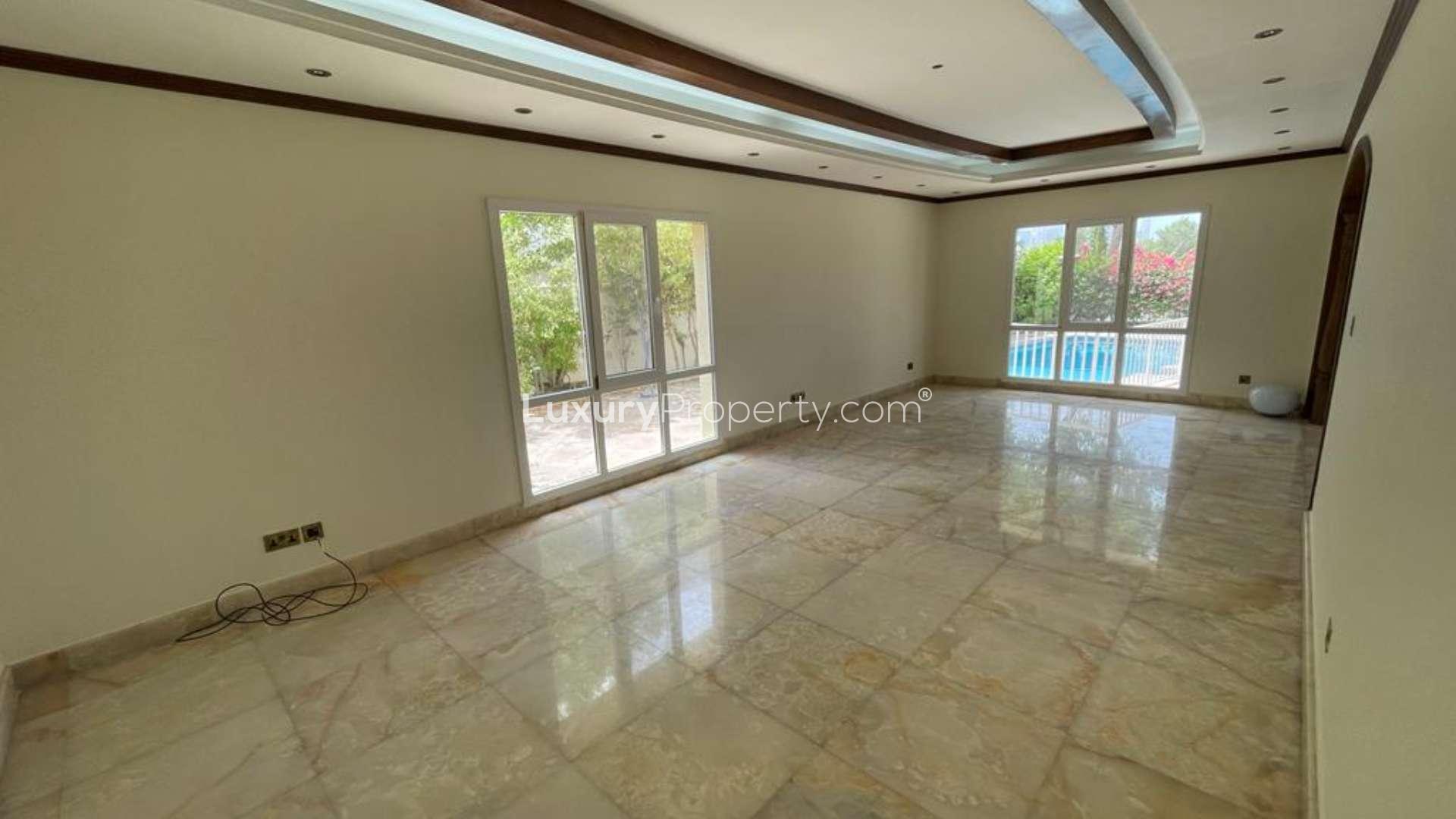 "Elegant staircase in fully upgraded villa, Meadows 5, with marble flooring and chandelier.",Spacious living area with large windows overlooking private pool in Meadows 5 villa