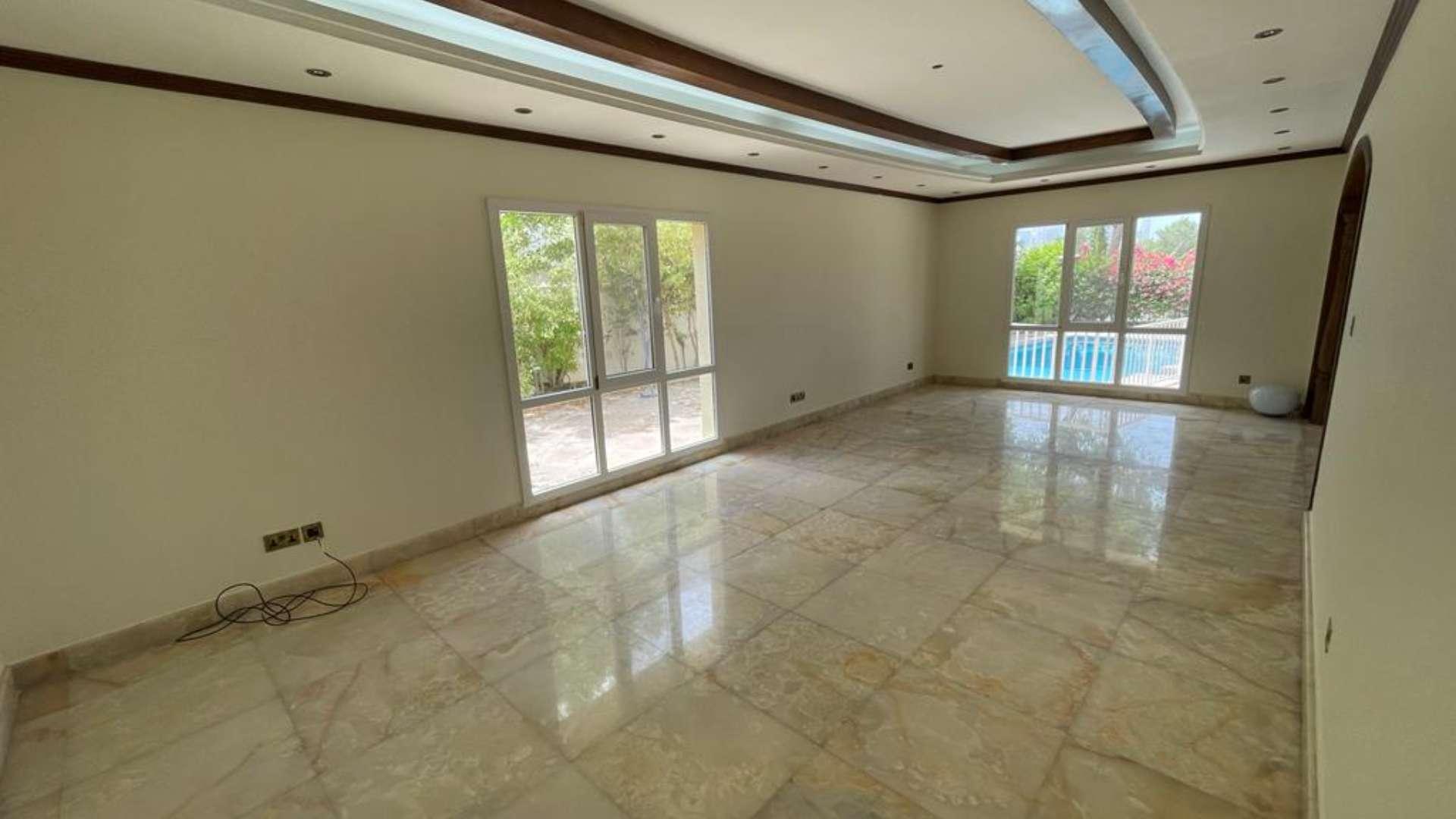 "Elegant staircase in fully upgraded villa, Meadows 5, with marble flooring and chandelier.",Spacious living area with large windows overlooking private pool in Meadows 5 villa