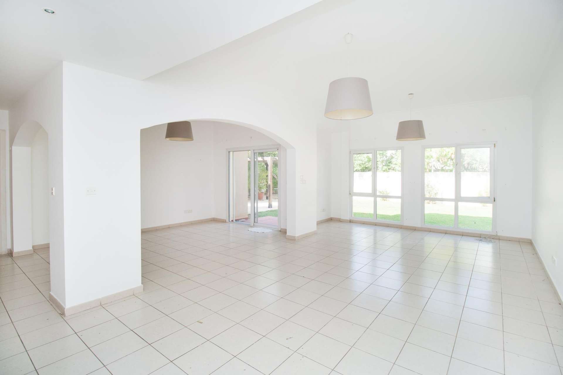 Spacious living area in 5-bedroom villa, Meadows 2, with garden view and tiled floors