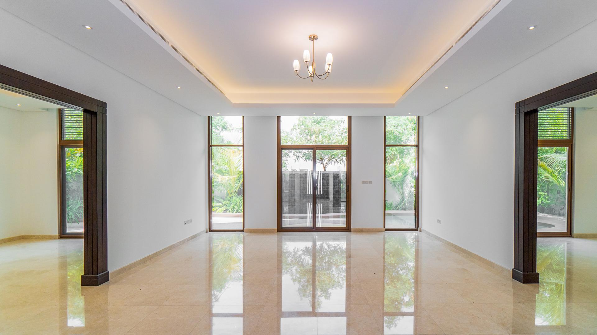 Spacious living room with large windows in Meydan Gated Community villa for rent