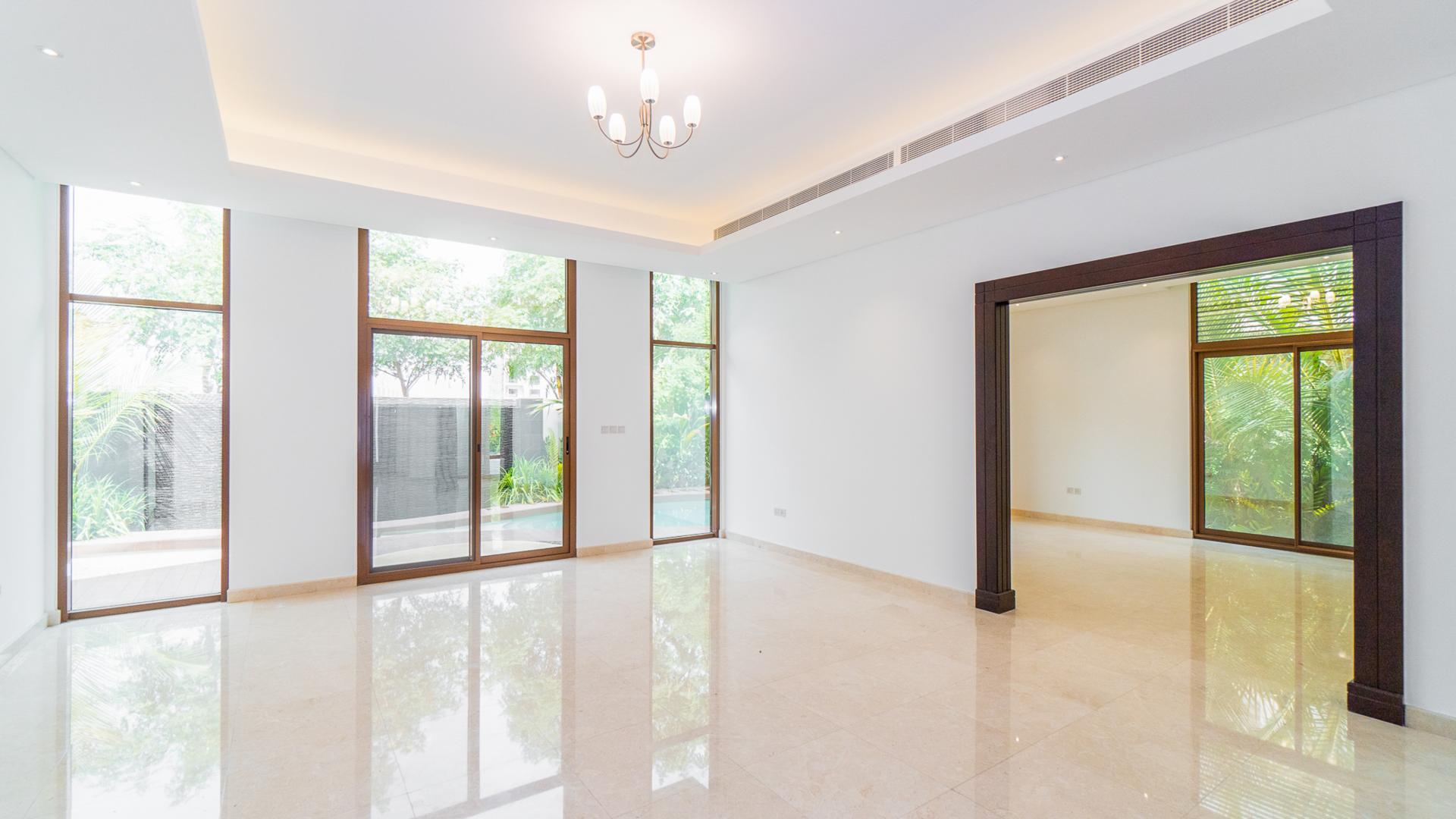 Modern villa interior with large windows and garden view in Meydan Gated Community