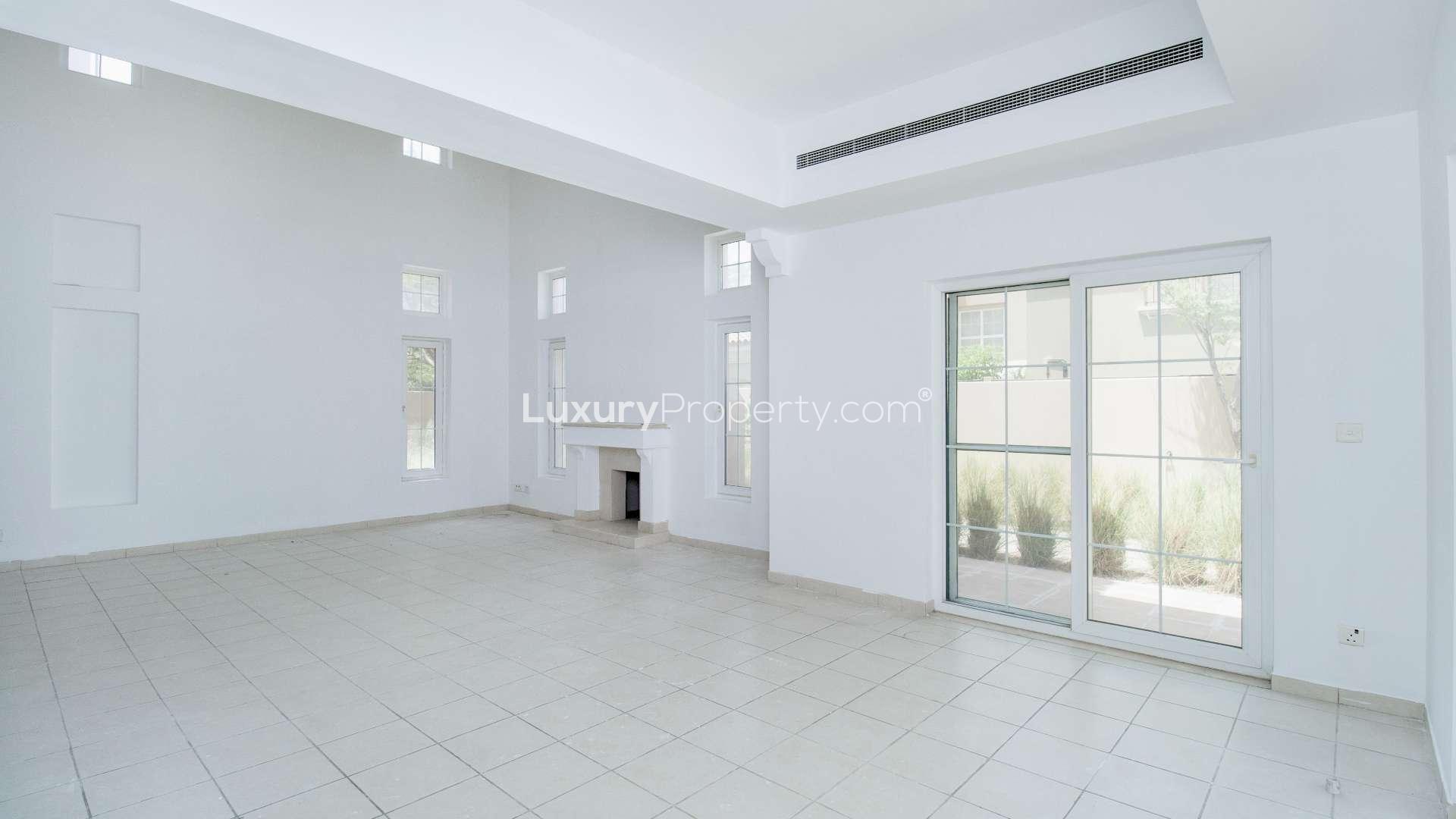 Spacious living room in 5-bed villa, Mirador, Arabian Ranches, with fireplace and large windows