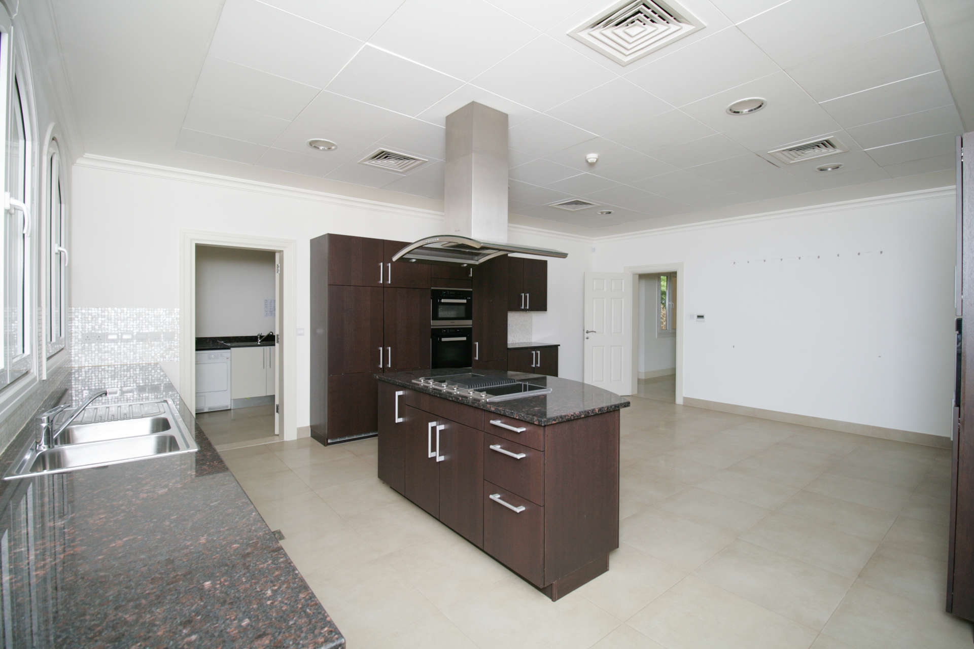 Modern kitchen with dark wood cabinets in 5-bedroom villa, Olive Point, Jumeirah Golf Estates