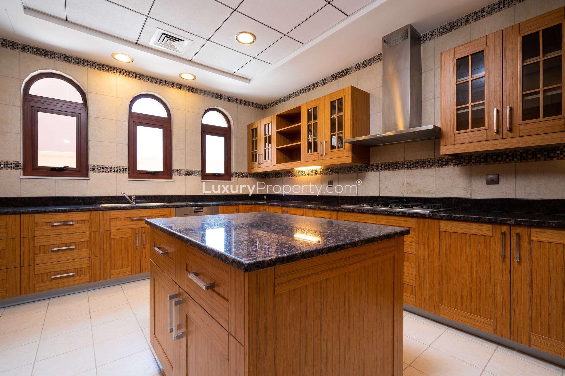 Spacious kitchen in 5-bedroom villa, Orange Lake, Jumeirah Golf Estates, wooden cabinets, island