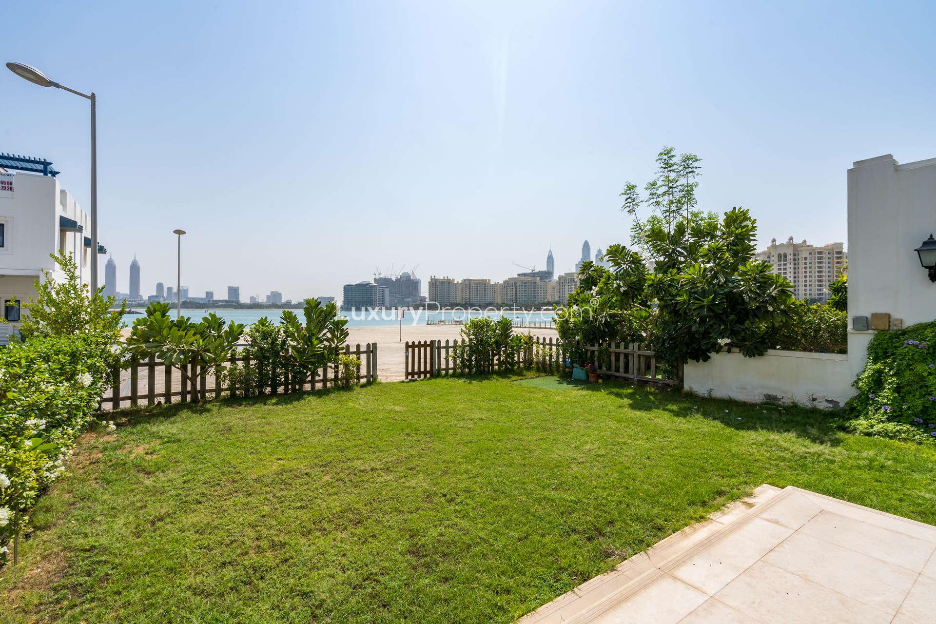 Spacious bedroom with wooden doors and blue-framed window in Palma Residences villa, Palm Jumeirah