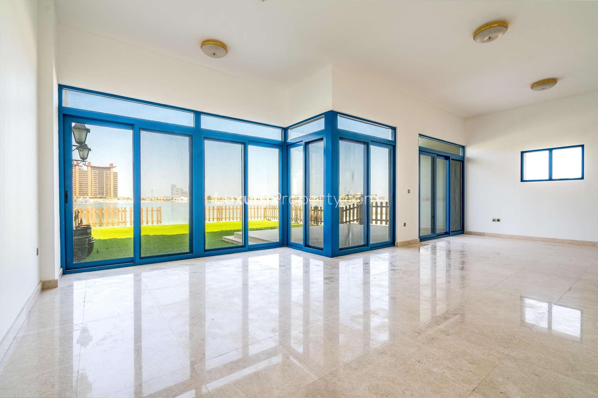 Empty room with wooden doors and blue window in Palma Residences townhouse, Palm Jumeirah