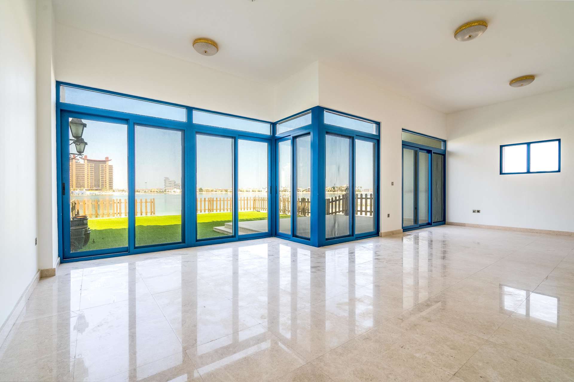 Empty room with wooden doors and blue window in Palma Residences townhouse, Palm Jumeirah