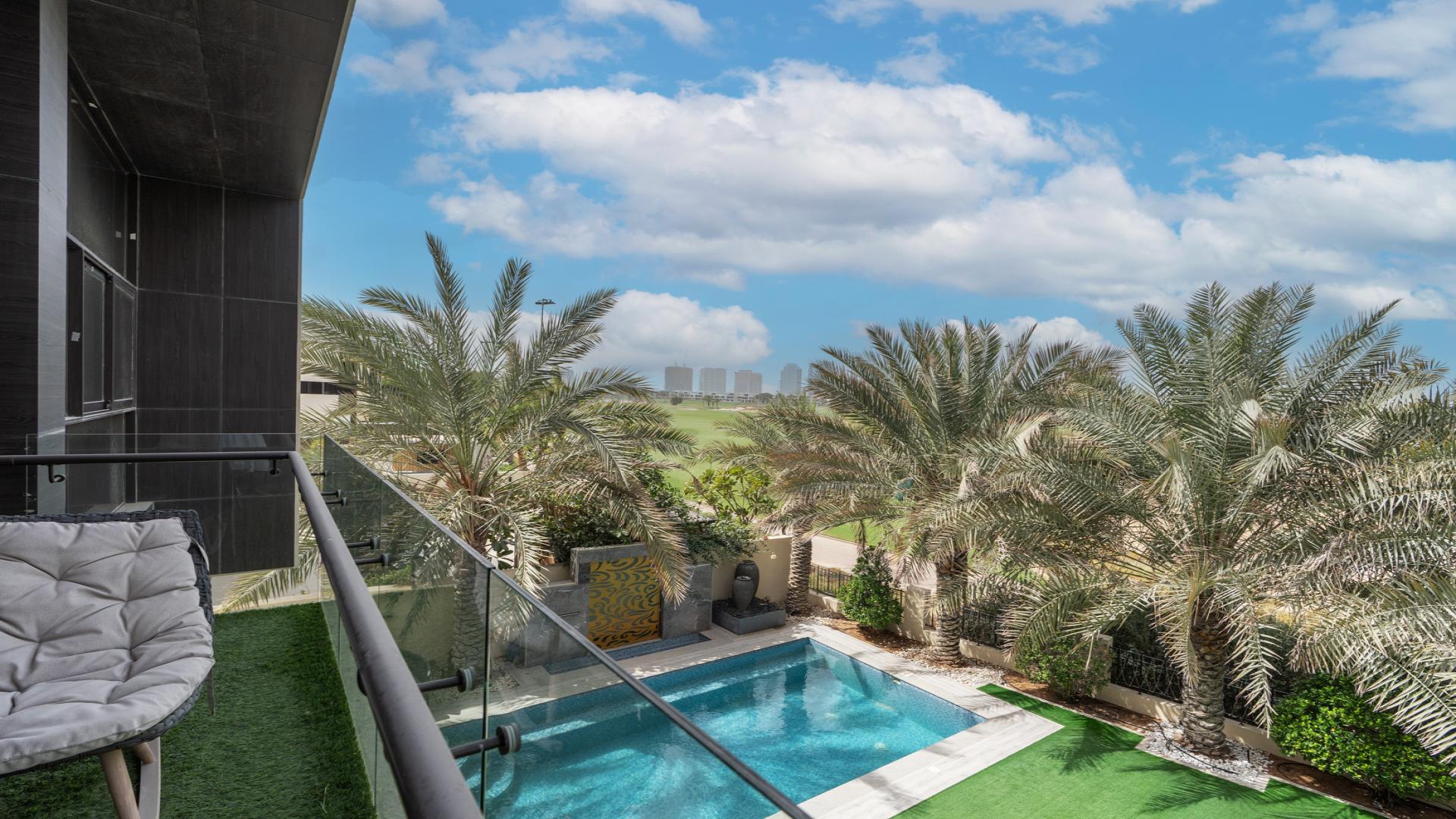 Elegant living and dining area in Damac Hills villa, featuring modern design and garden views