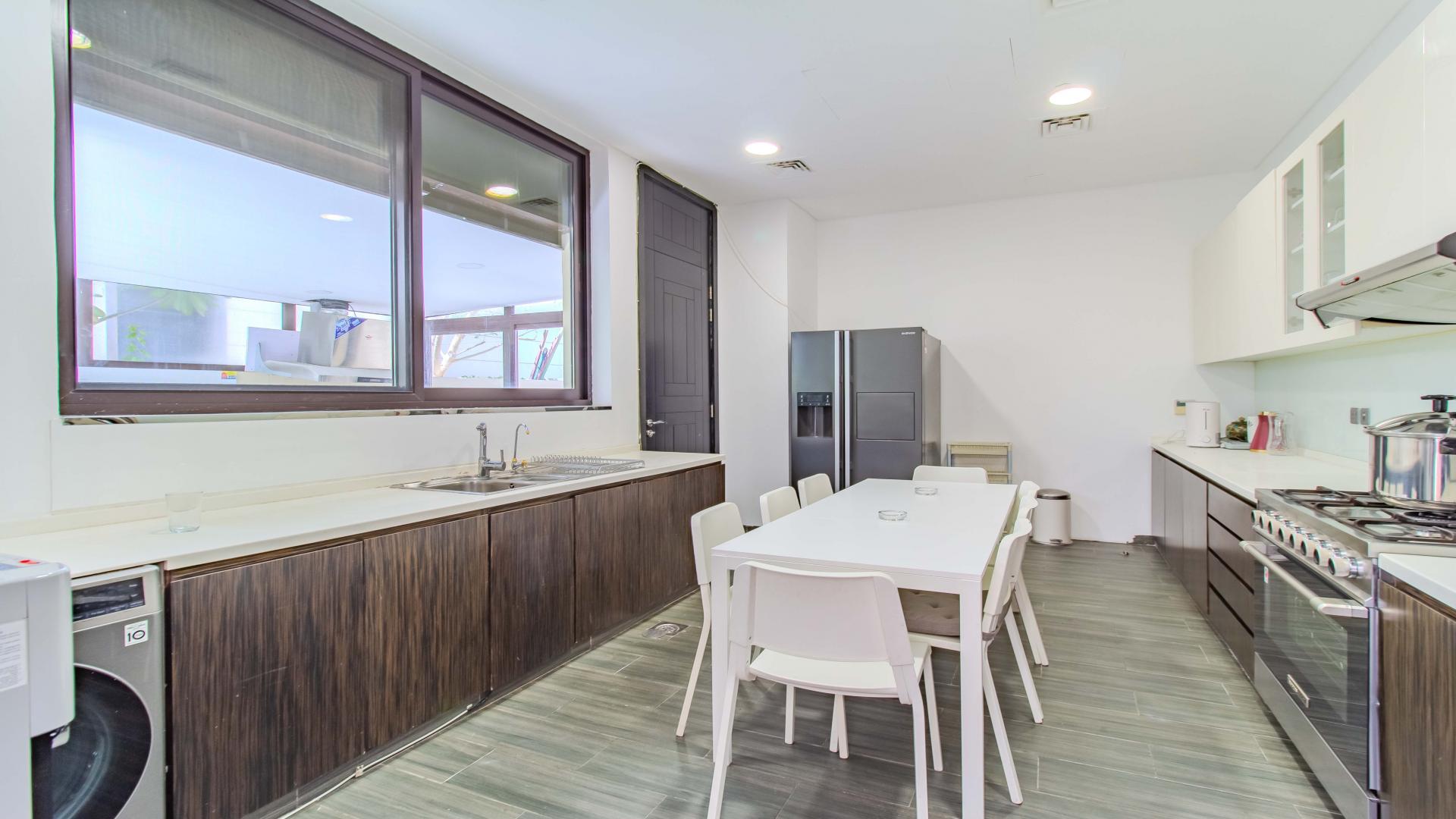 Bright bedroom in upgraded Flora villa, Damac Hills, featuring large windows and modern furniture