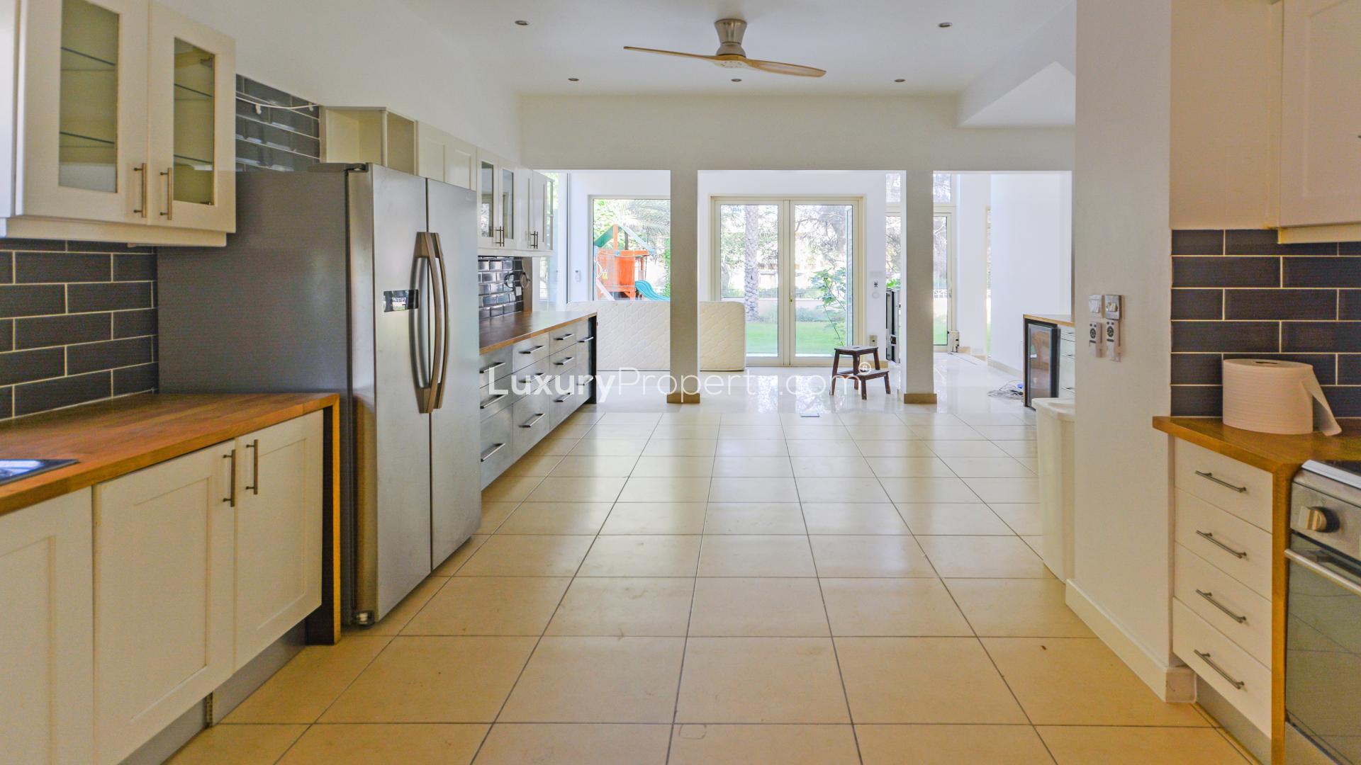 "Front view of 3-bedroom villa with garden in Saheel 1, Arabian Ranches for rent.",Kitchen with modern appliances and garden view in Saheel 1, Arabian Ranches villa