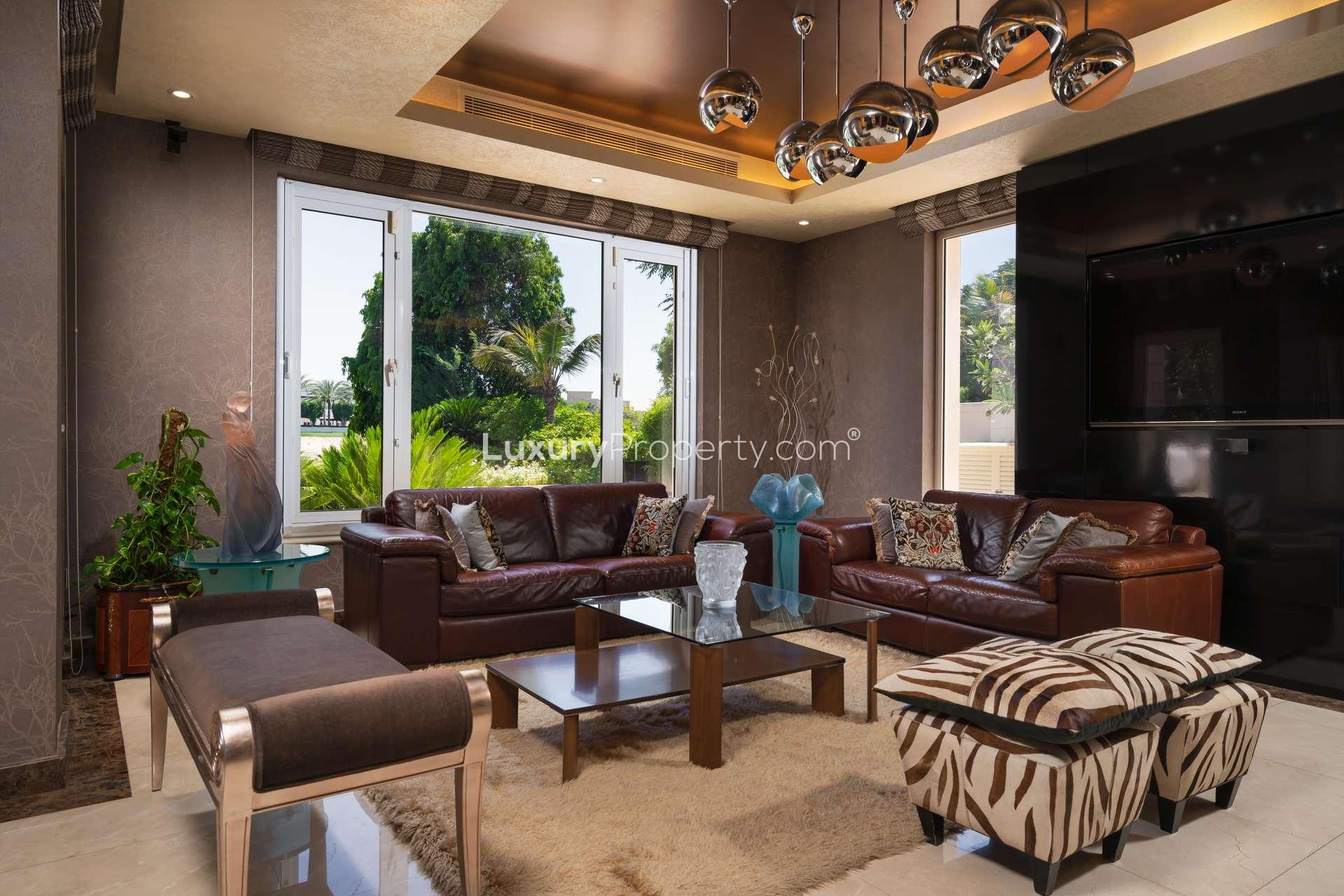 Elegant dining area in 5-bedroom villa, Emirates Hills, featuring luxurious decor and chandelier