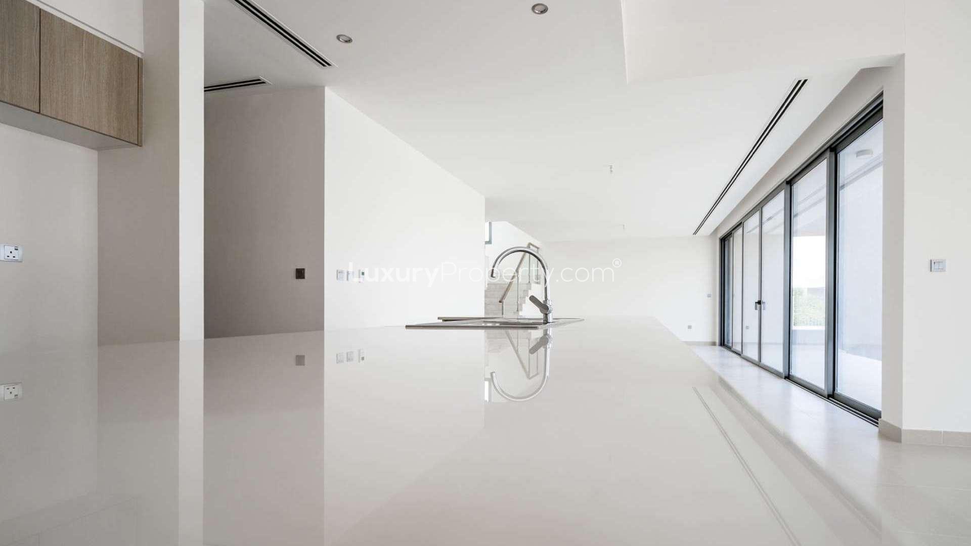 "Spacious modern kitchen and living area in Sidra Villas, Dubai Hills Estate rental villa.",Modern kitchen with sleek countertops and large windows in Sidra I, Dubai Hills Estate villa