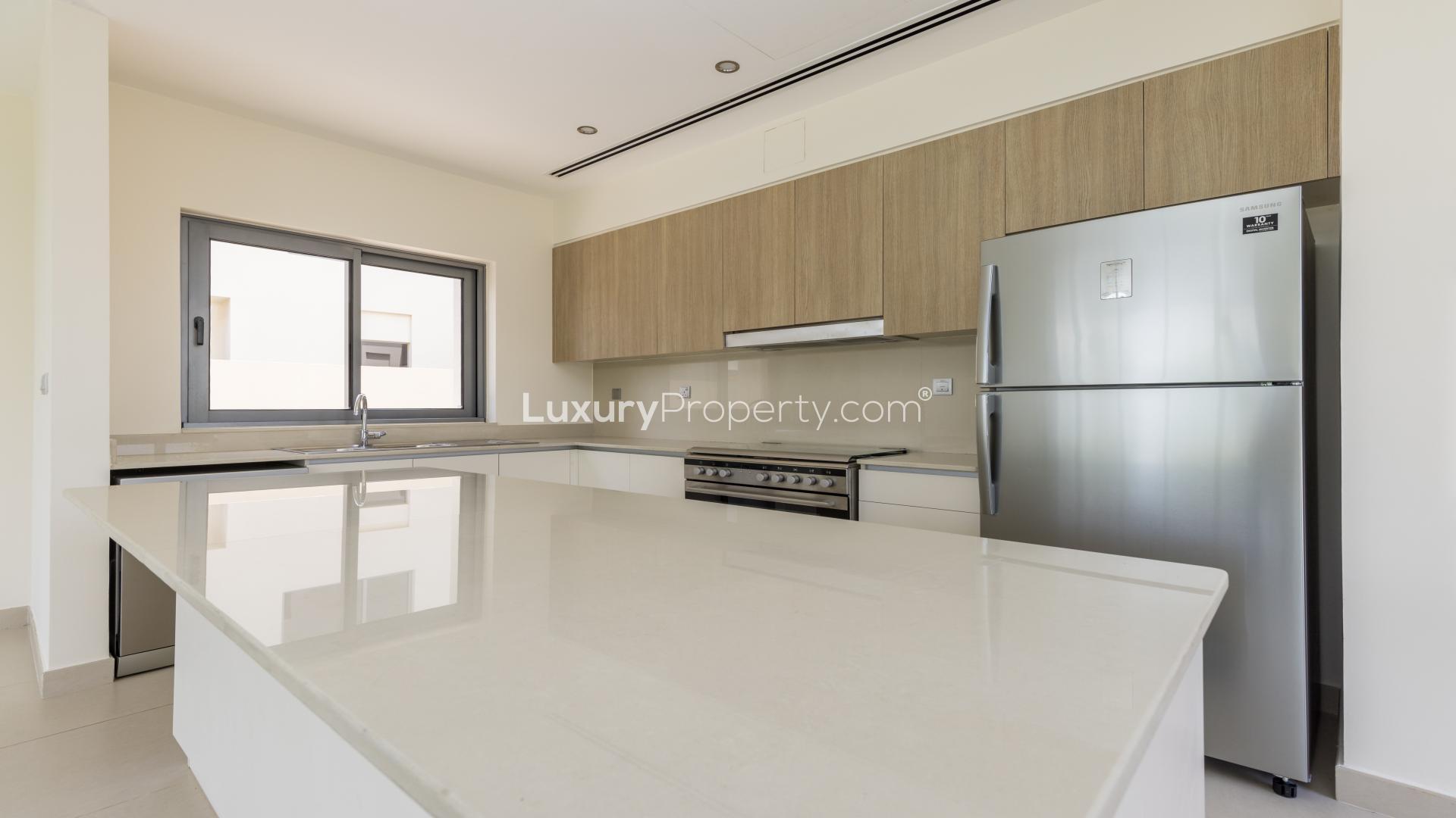 "Dubai Hills Estate villa with landscaped garden and green belt views in Sidra Villas.",Modern kitchen in Sidra Villas, Dubai Hills Estate, with sleek countertops and stainless appliances