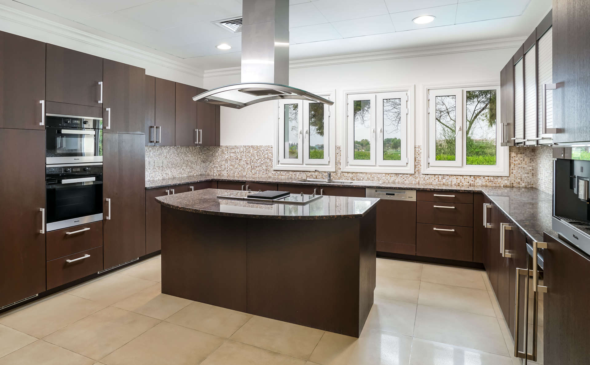 Spacious empty room with chandelier in Jumeirah Golf Estates villa, tiled floors, large window