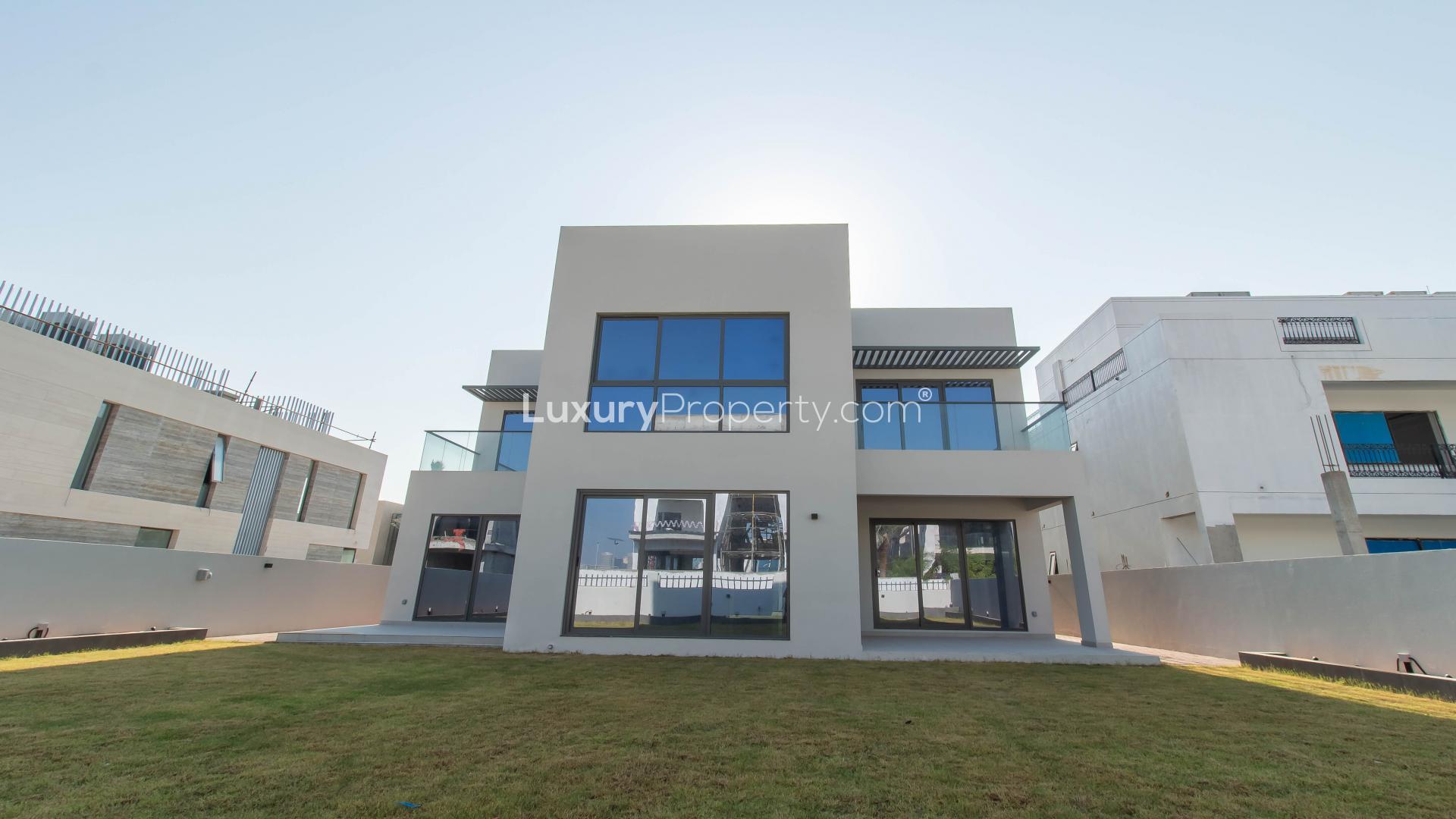 Modern kitchen in 5-bedroom villa, Jumeirah Park, featuring sleek countertops and large windows