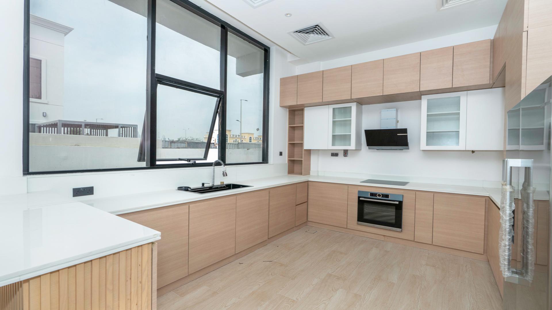 Modern kitchen in spacious 5-bedroom villa, Jumeirah Park Homes, featuring sleek design and large windows