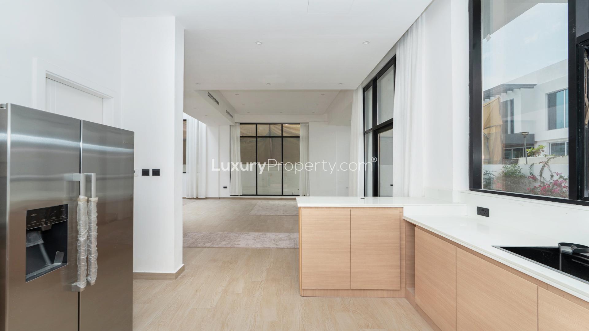 Open-plan kitchen and living area in Jumeirah Park villa with modern staircase