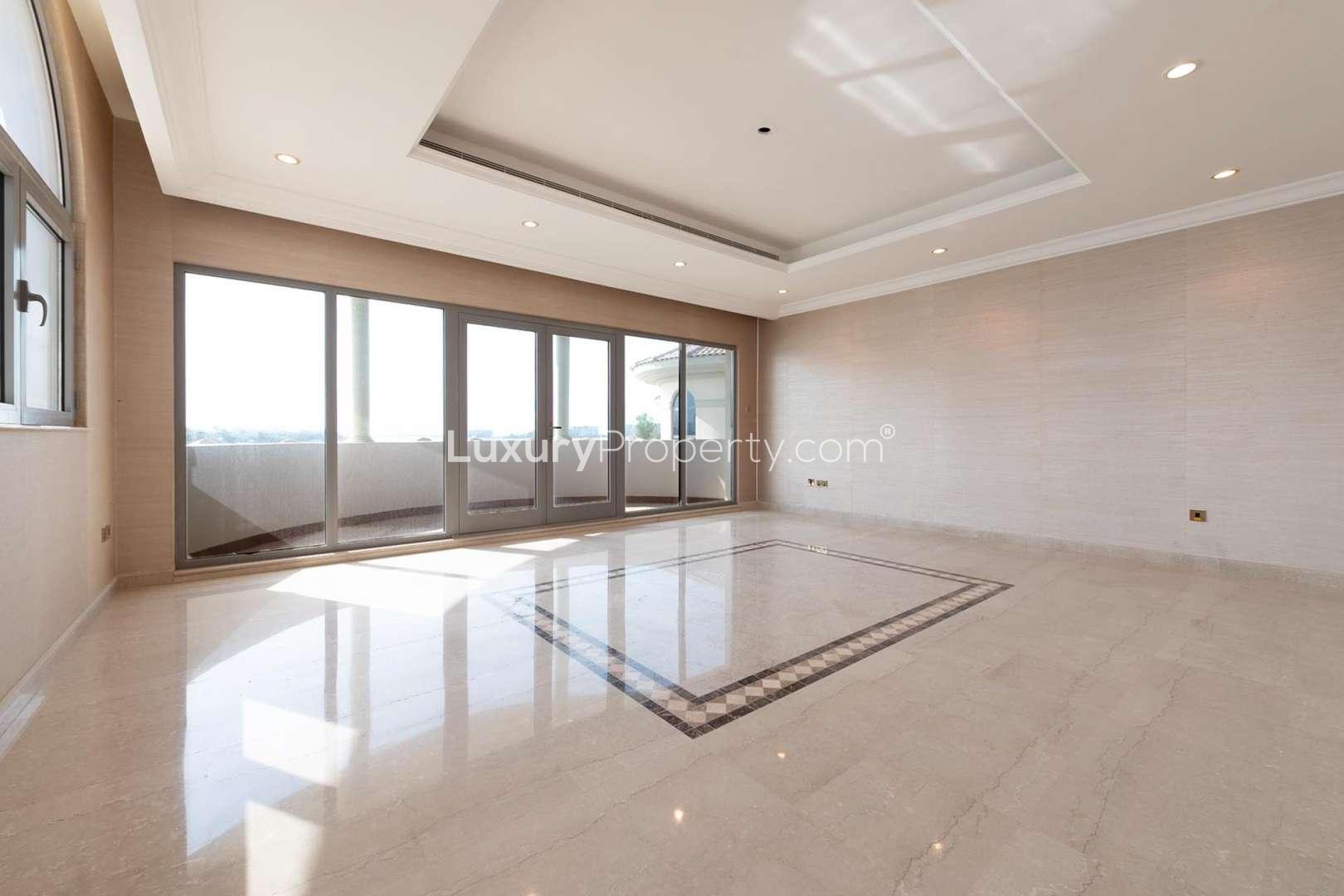 Spacious bedroom in Palm Jumeirah villa with elegant wooden wardrobe and arched window
