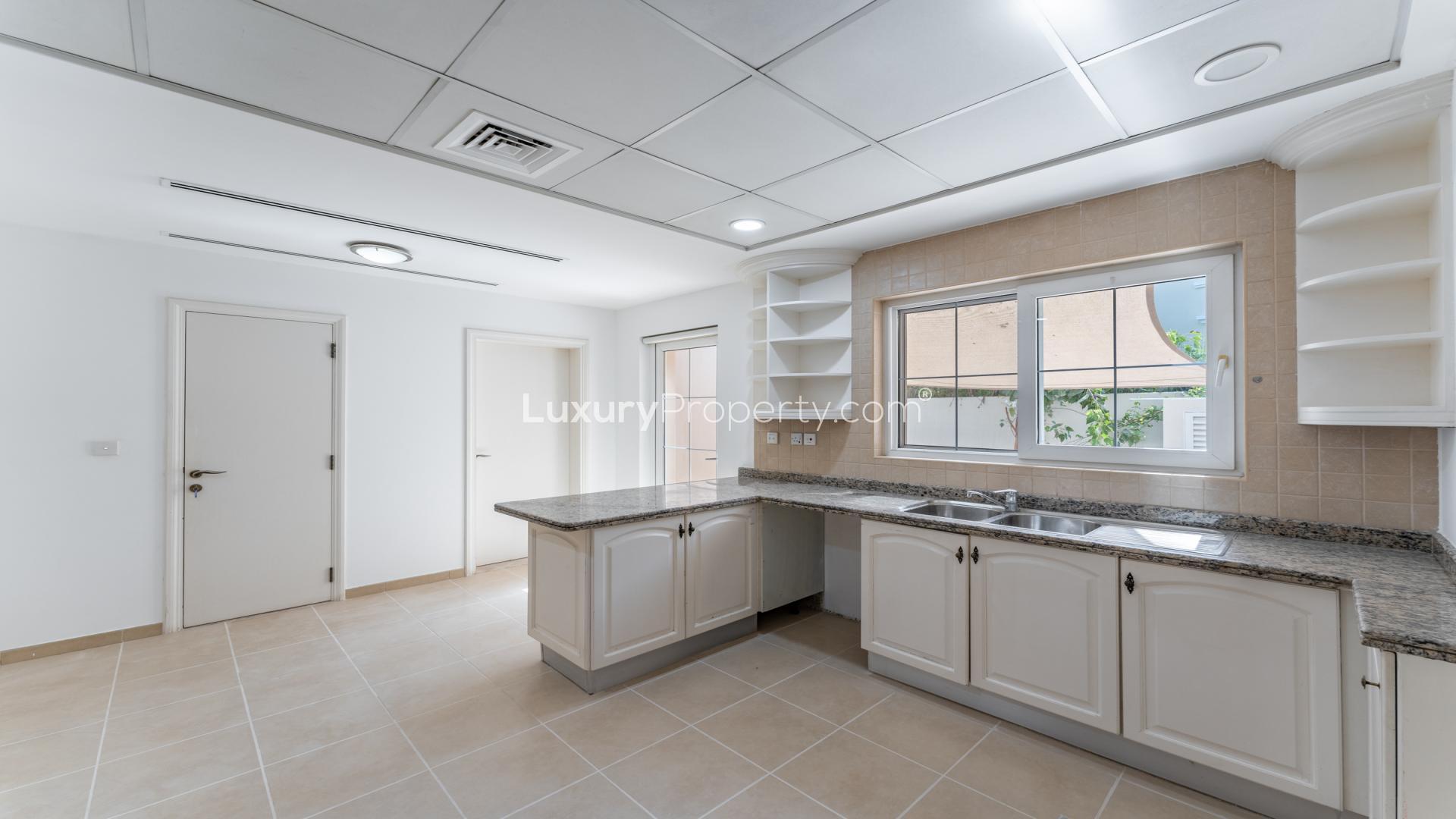 "Spacious villa interior with pool view, Arabian Ranches Alvorada, 5 bedrooms, 6 bathrooms.",Modern kitchen in Alvorada villa, Arabian Ranches, featuring granite countertops and ample storage