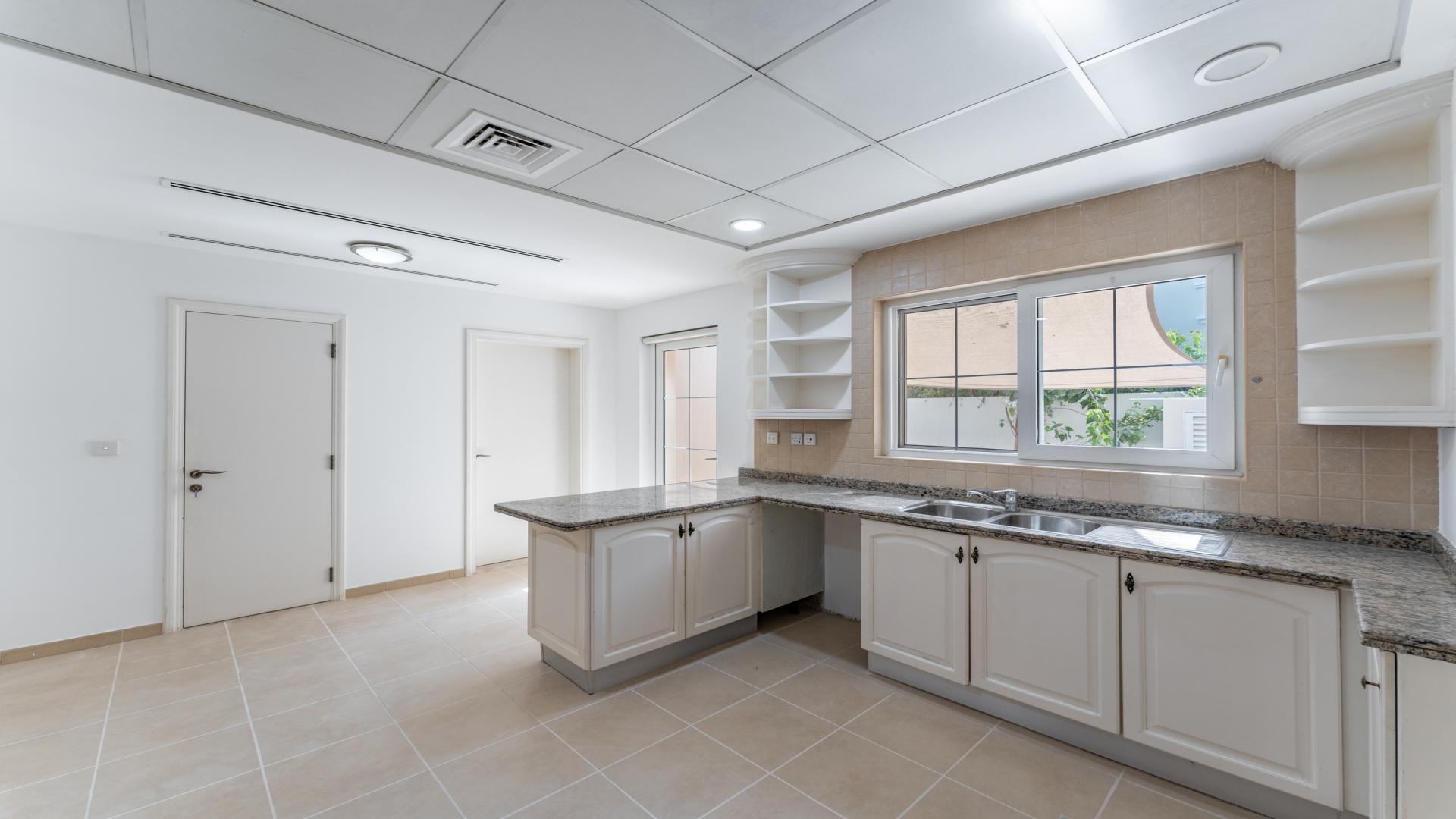 "Spacious villa interior with pool view, Arabian Ranches Alvorada, 5 bedrooms, 6 bathrooms.",Modern kitchen in Alvorada villa, Arabian Ranches, featuring granite countertops and ample storage