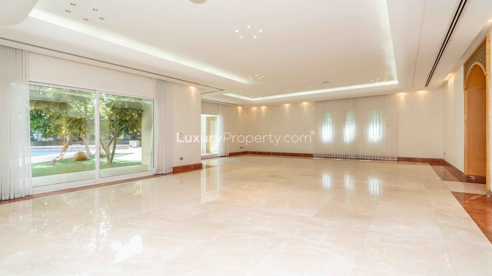 Dining room in Emirates Hills villa with elegant glass table and white chairs