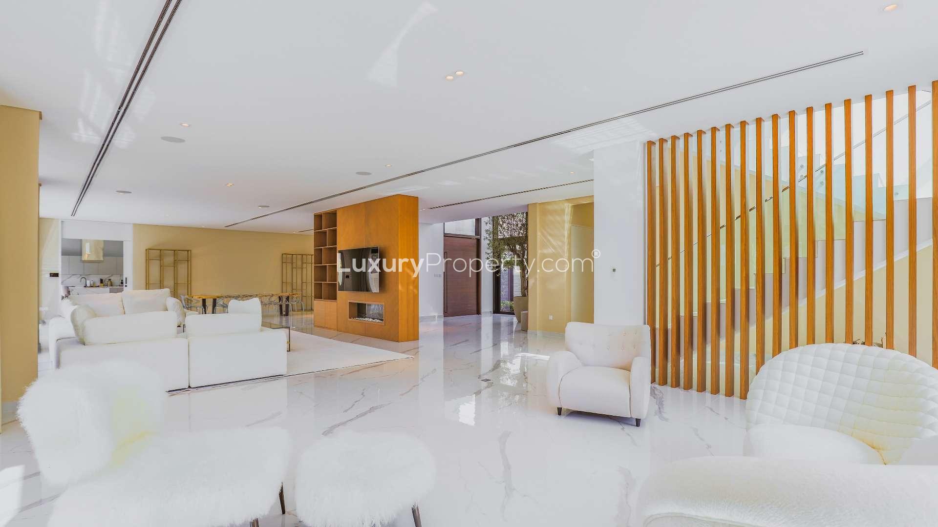 Outdoor dining area in Al Barari villa with wooden pergola and lush garden views