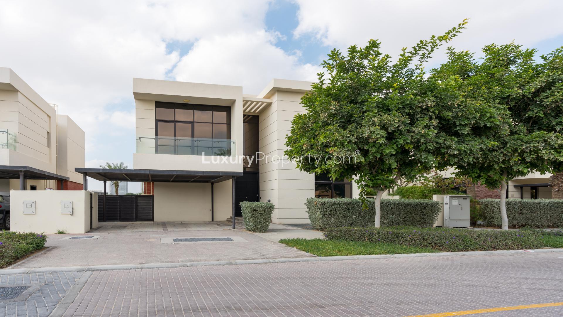 Spacious living area with large windows and golf course views in Damac Hills villa