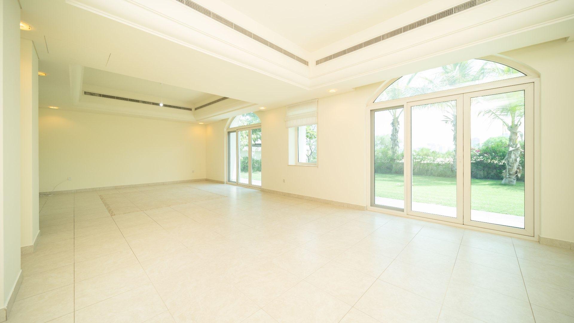 Spacious villa living room with large windows overlooking garden, Victory Heights, Dubai Sports City