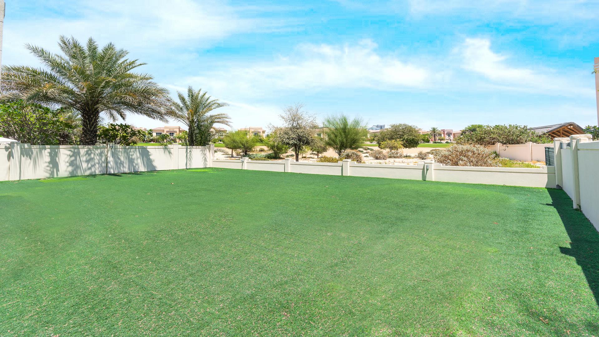 Spacious backyard with lush greenery at 5-bedroom villa in Victory Heights, Dubai