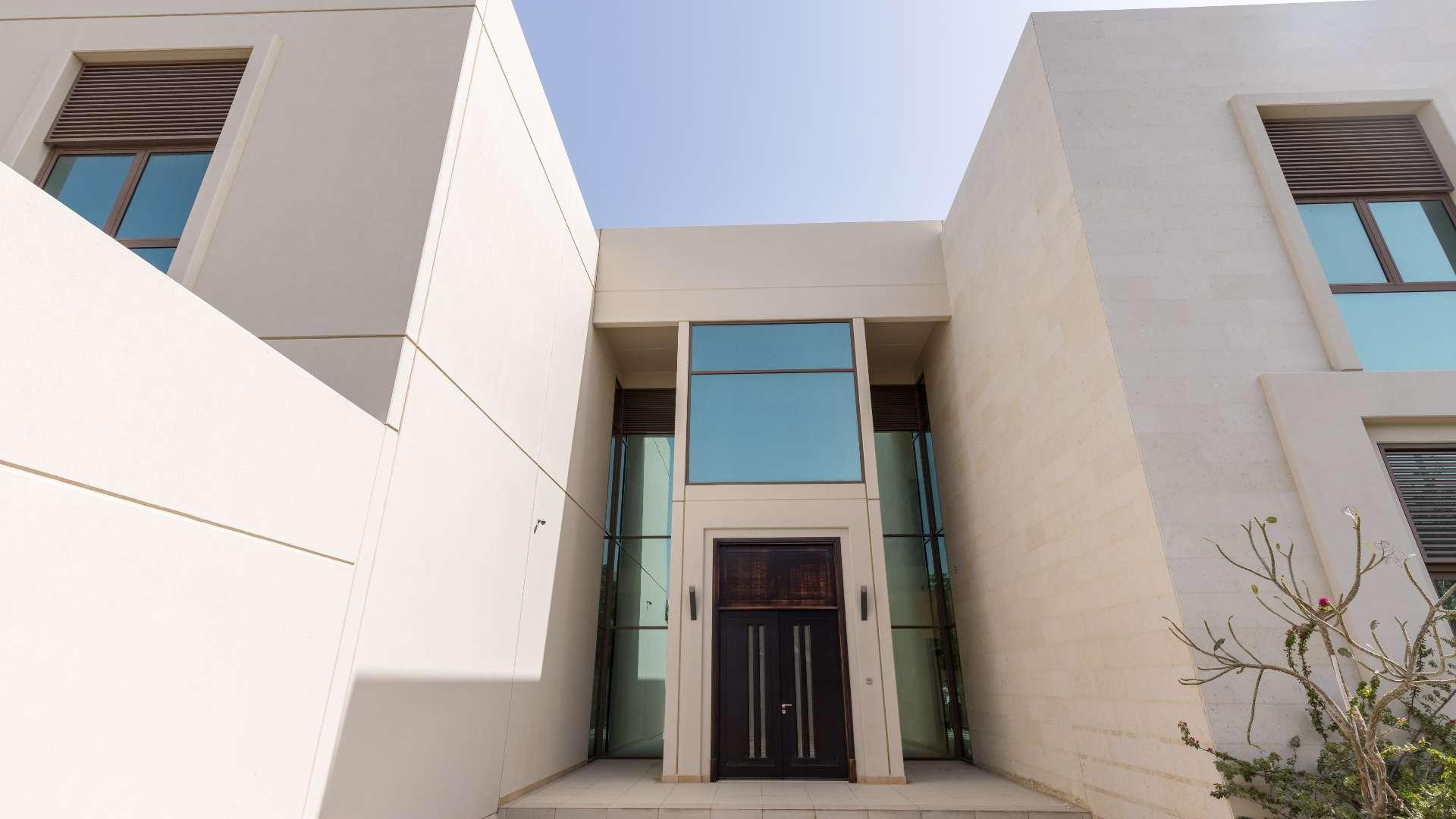 Alt text: "Elegant villa exterior with lush greenery in Meydan Gated Community, Millennium Estates.",Spacious five-bedroom villa entrance in Millennium Estates, Meydan Gated Community, for sale