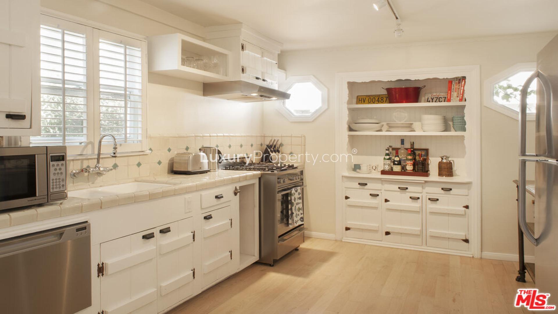 Cozy living room in five-bedroom Craftsman villa, Venice, CA, featuring rustic wood ceiling