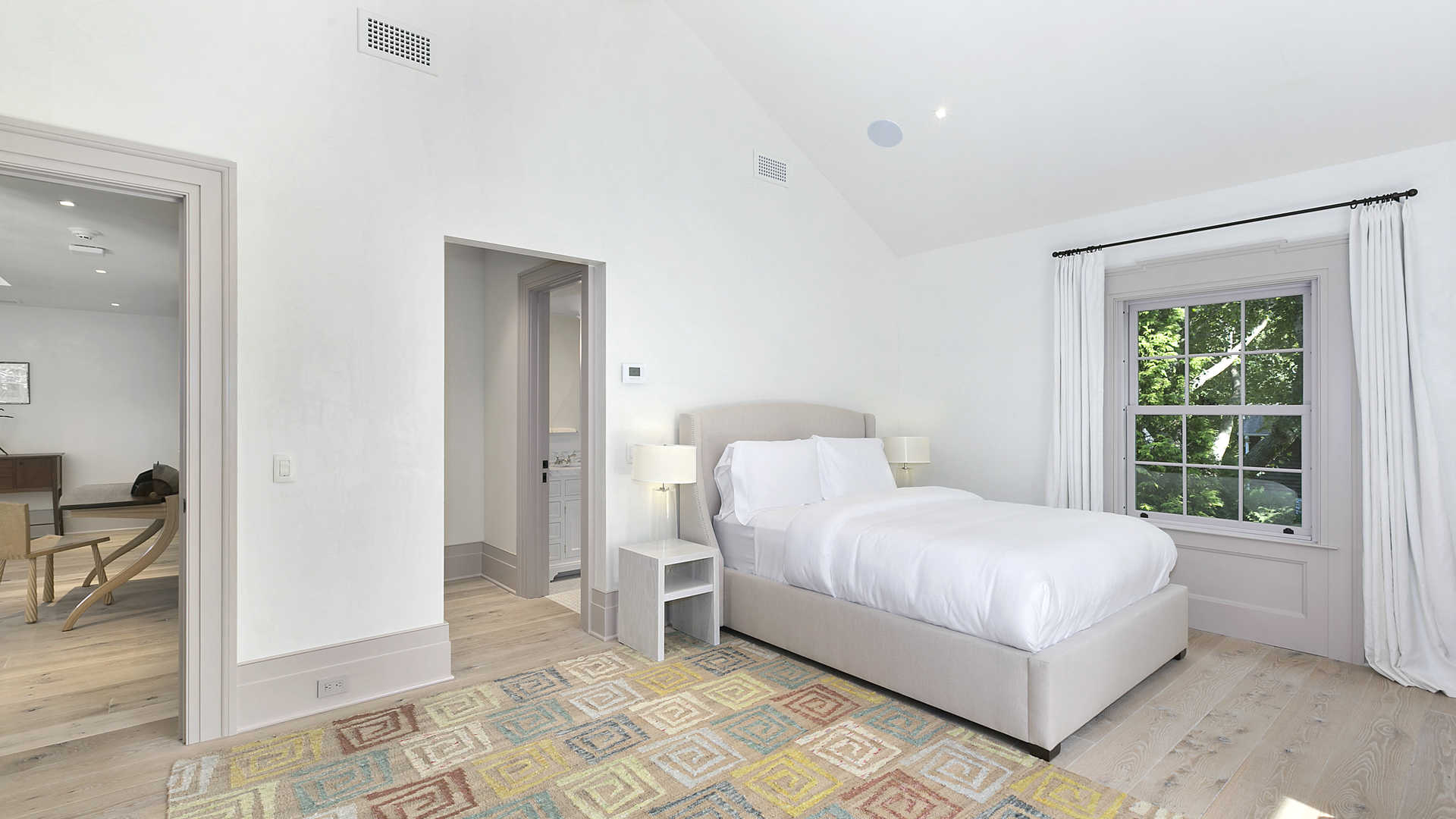 Elegant living room in Sag Harbor villa with leather chairs and large windows